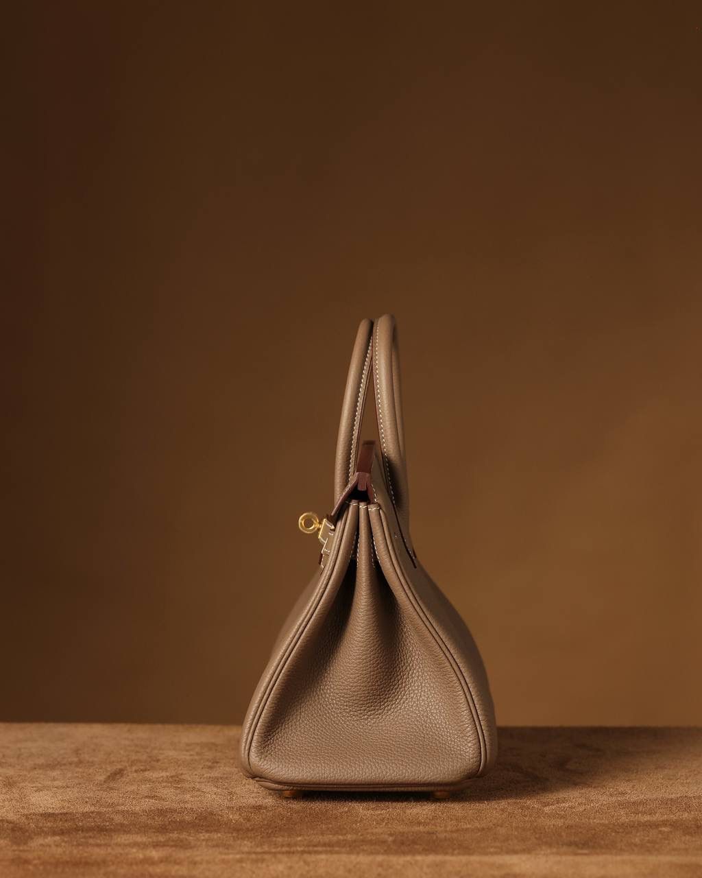 Hermes 爱马仕 Birkin25cm 大象灰金扣👜✨ Birkin 独家渠道货 独家欧洲原厂皮原厂五金组装的ZP尾单货 尺寸：20 X 25 X 13CM Birkin我们采用的是进口原厂Togo真皮，什么是Togo皮呢？ Togo皮：最经典的Birkin用皮。表面是均匀的颗粒状，类似荔枝纹，有光泽。皮质较硬，容易保持包包的形状，相对较轻，触感比较柔软，耐磨耐用； 我们用的是纯原、原厂皮就是和原版专柜一样的皮！