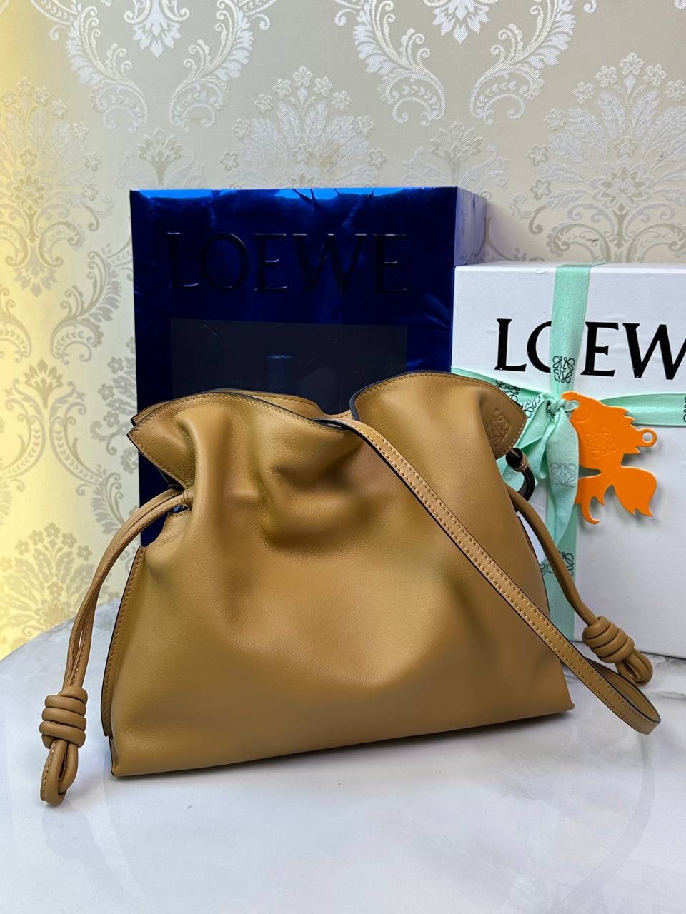 Flamenco clutch✦中号✦ 尺寸：𝟑𝟎-𝟐𝟒.𝟓-𝟏𝟎.𝟓𝐜𝐦 型号：052028 棕色 ❤️flamenco clutch bag可手拿亦可优雅斜挎 云朵般温暖亦轻盈的造型如此简单，💯耐看💯不会out的款式！ ❤️包袋采用进口小牛皮，手感如羊皮般细腻柔软，却比羊皮更加结实耐用，麂皮内衬 ❤️品牌标志性绳结设计，收紧袋口就是小福袋造型，超Q，看着不大实际超会装😇