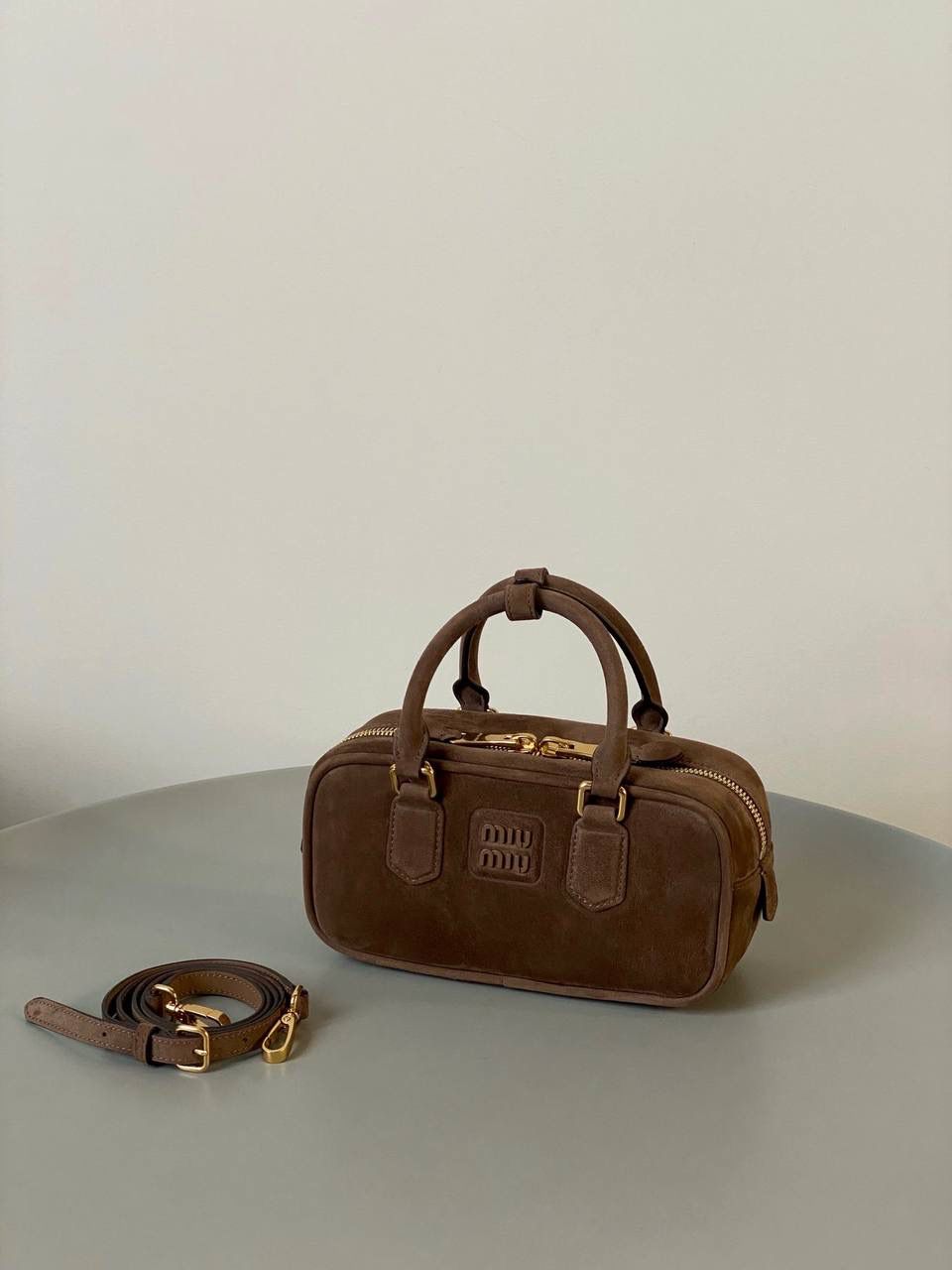 🈶可可棕，小号 𝗠𝗶𝘂𝗠𝗶𝘂24秋冬保龄球 今年棕麂皮系列大人气啊！深深的巧克力色，满满秋冬味儿～ 绒面皮每年都会有，但是！！今年这股风刮的特别猛 从秀场到ins博主穿搭，或者线上门店 几乎都有麂皮元素！ 西装款 夹克 风衣 鞋子 包括包包等 延续去年美拉德色系的颜色， 今年的颜色各种各样，有深有浅 但我唯爱咱miu家的这个巧棕色 绝对秋冬氛围感里，最“增质感”的时髦单品！ 小号：10.5×22×7.5cm #F0011m 大号：27x12x9cm