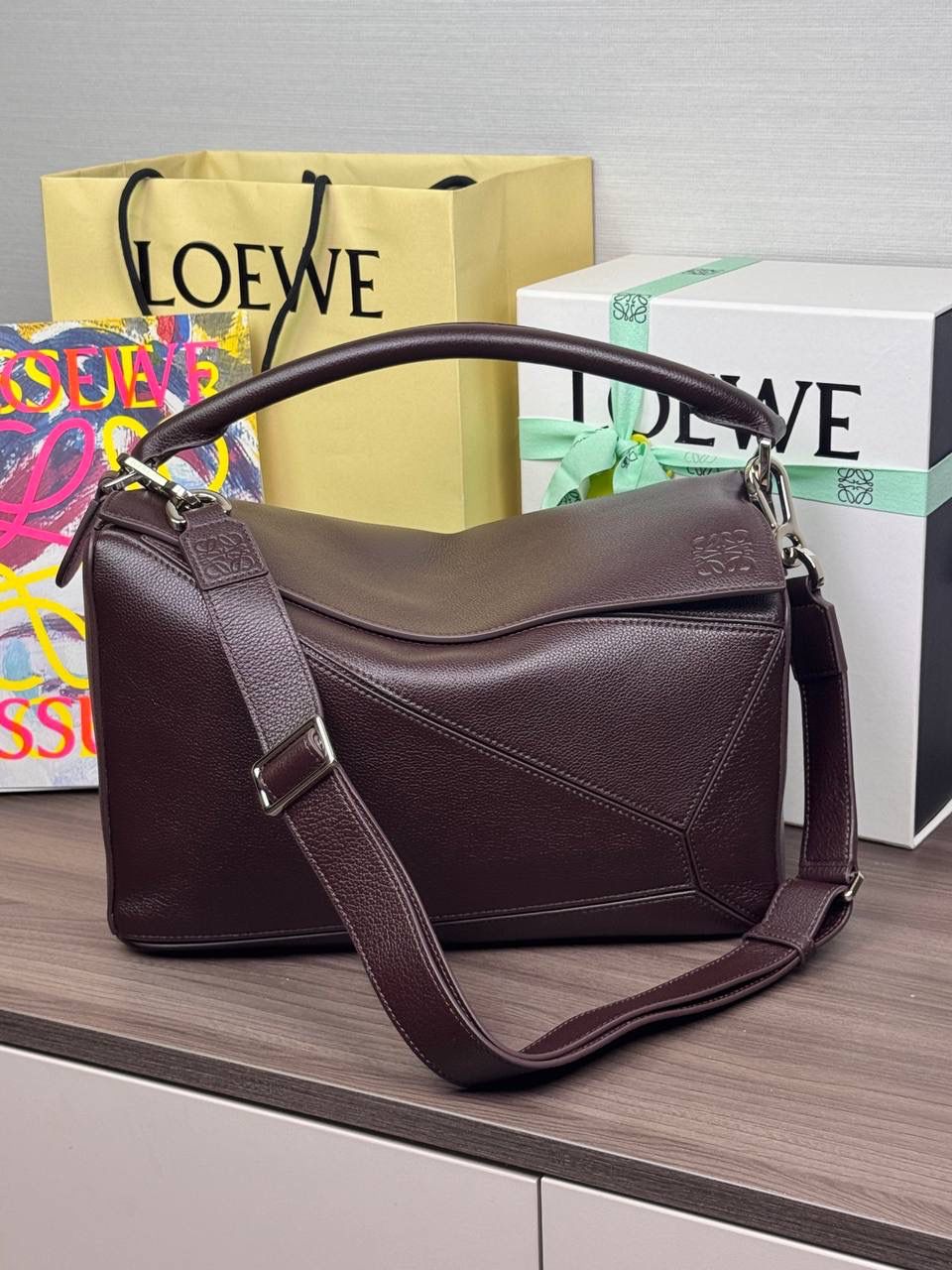 🎈【全钢】大号鹿皮𝘗𝘶𝘻𝘻𝘭𝘦* ——【👉🏻牛血色到货✅】 尺寸：𝟑𝟐.𝟓-𝟏𝟒.𝟓-𝟐𝟑.𝟓𝐜𝐦 编码：260403 【配全套包装】 ❤️经典拼图系列•不规则立体几何设计•最具辨识度的立体廓形和几何美学•顶级进口皮搭配德国沙菲线•独家定制五金•𝗬𝗞𝗞拉链拉头。 ❤️该款大号采用鹿皮革制成•绒面内里•搭配一条可拆卸可调节的皮肩带•肩背斜挎或手提多样化背法。