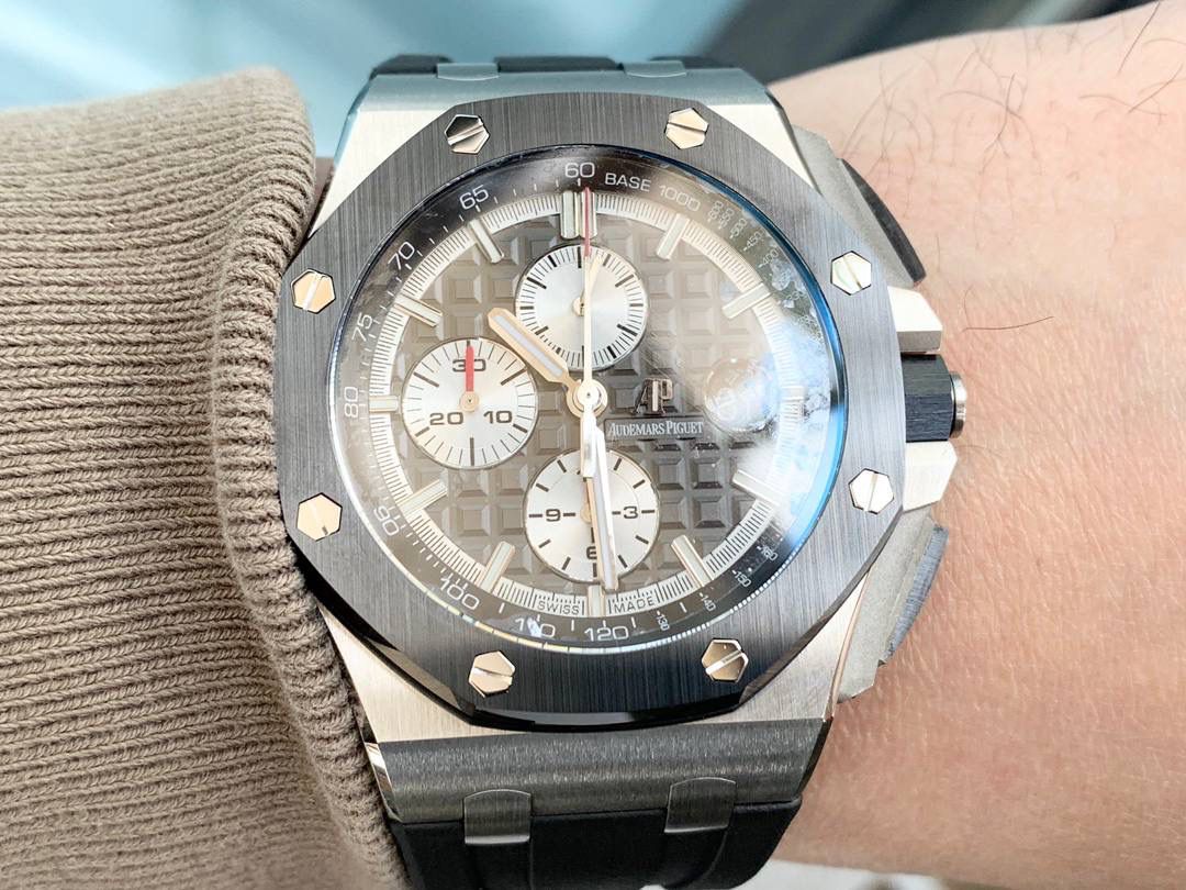 表盘以爱彼经典的大格纹为背景，一个个层次分明的方格排列，经过完美的打磨，将尽善尽美体现得淋漓尽致。三点位的日历表盘，在蓝宝石玻璃凹透镜的作用下，TPE扩大效果与原版一般无二。每一根大小表针，无论从各个角度来看都没有出现毛刺现象，这一点解决了大部分强迫症表友一直存在的烦恼！刻度与表针中间部位都采用瑞士进口夜光粉，每一个个体都做到手工填充，均匀饱满度是机器填充远远比拟不了的，亮度与发光颜色与原版几乎一致！机芯方面采用7750改3126的计时机芯，十二位的小秒，六点位和九点位的12小时计时与30分钟计时，完美的还原了原版的所有功能，经过JJF团队的精密打磨，大大提升了7750基础机芯的稳定性，缓解了一直以来计时机芯款式空有其表的尴尬现象！做到无可挑剔，堪称天花板级别，欢迎广大表友品鉴！