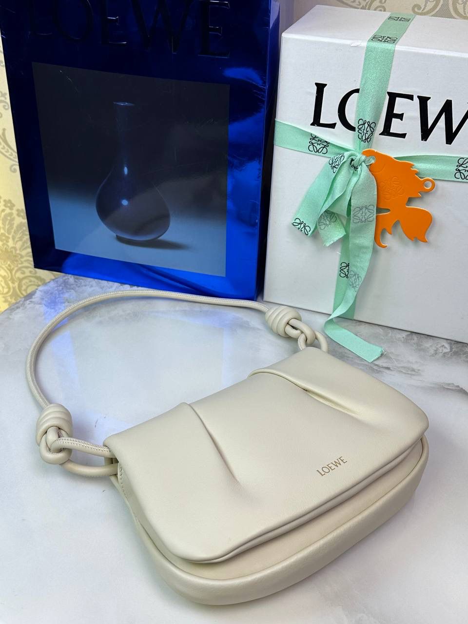 全新*𝙋𝙖𝙨𝙚𝙤 𝙨𝙖𝙩𝙘𝙝𝙚𝙡 手袋🛍️【米白】 —— 朕品1w7➕😘 尺寸:𝟐𝟓-𝟏𝟕-𝟖𝐜𝐦 编码:062318 ✅做工精致，廓形简洁优雅，独特、柔软的褶襇结构，超轻盈构造，纳帕软牛皮革（里外全皮），顶部饰有flamenco螺旋绳结。 ✅配置双肩带，短手柄肩带可做腋下包不可拆卸，长肩带可肩背可斜挎可拆卸调节，磁扣开合设计，多种背法随心所欲❤