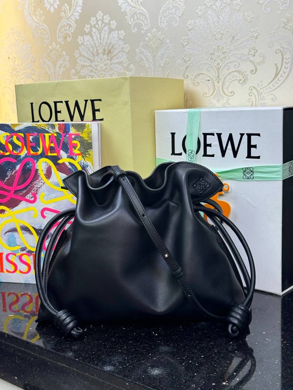 Flamenco clutch✦中号✦ 尺寸：𝟑𝟎-𝟐𝟒.𝟓-𝟏𝟎.𝟓𝐜𝐦 型号：052028黑色 ❤️flamenco clutch bag可手拿亦可优雅斜挎 云朵般温暖亦轻盈的造型如此简单，💯耐看💯不会out的款式！ ❤️包袋采用进口小牛皮，手感如羊皮般细腻柔软，却比羊皮更加结实耐用，麂皮内衬 ❤️品牌标志性绳结设计，收紧袋口就是小福袋造型，超Q，看着不大实际超会装😇