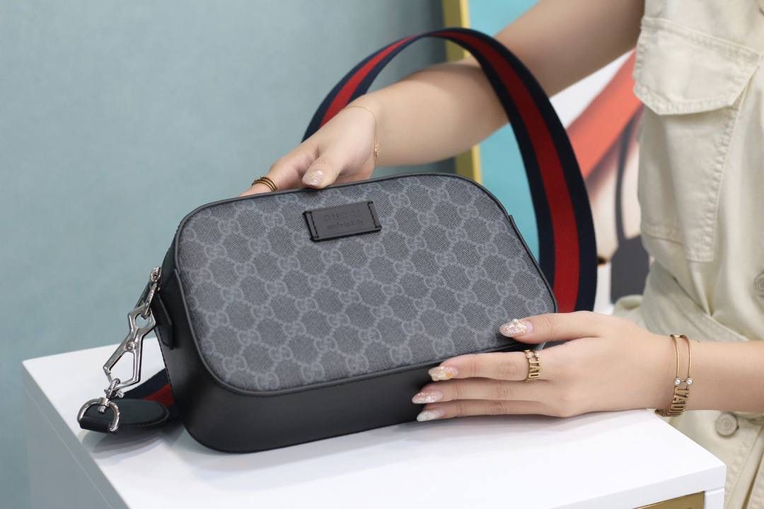 #原厂正品皮#574886 尺寸：24*14*7cm 在虎头相机包的爆款的基础上 新增加相机男士新成员，这次以往不同的是采用了黑色双G面料，让一个中性男女可用的相机包立马呈现了男士阳刚之气，上身帅气十足却又不失时尚大方的气质，蓝配红织带的搭配，让整个包有了时尚感，男士们的首选！推荐入手！成熟而稳定的高端技术，让整个包散发出娘胎里该有的味道！🔥🔥