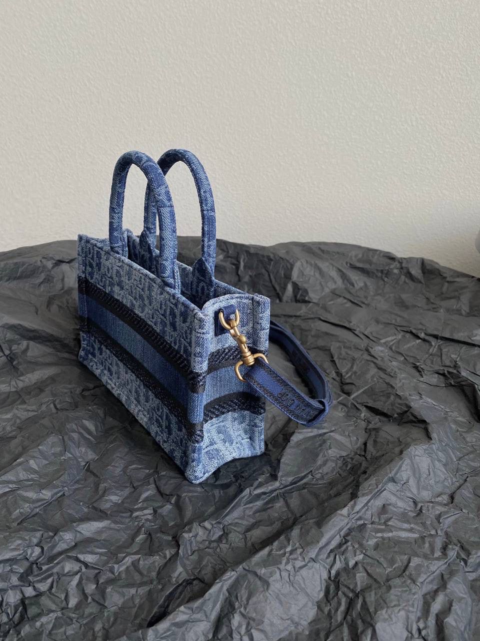 🈶牛仔蓝迷你 𝗖𝗗 𝗕𝗼𝗼𝗸 𝗧𝗼𝘁𝗲 24石洗丹宁 这期的牛仔系列真的超爱！ 它的热度不亚于任何一只经典款 深蓝色丹宁➕经典的Oblique印花， 不规则石洗效果，渐变感特别且帅气 牛仔很百搭也没有什么季节性， 所以这系列是既特别又经典 不怕过时 姐妹们可以放心冲！💕💕 21.5×13×7.5cm