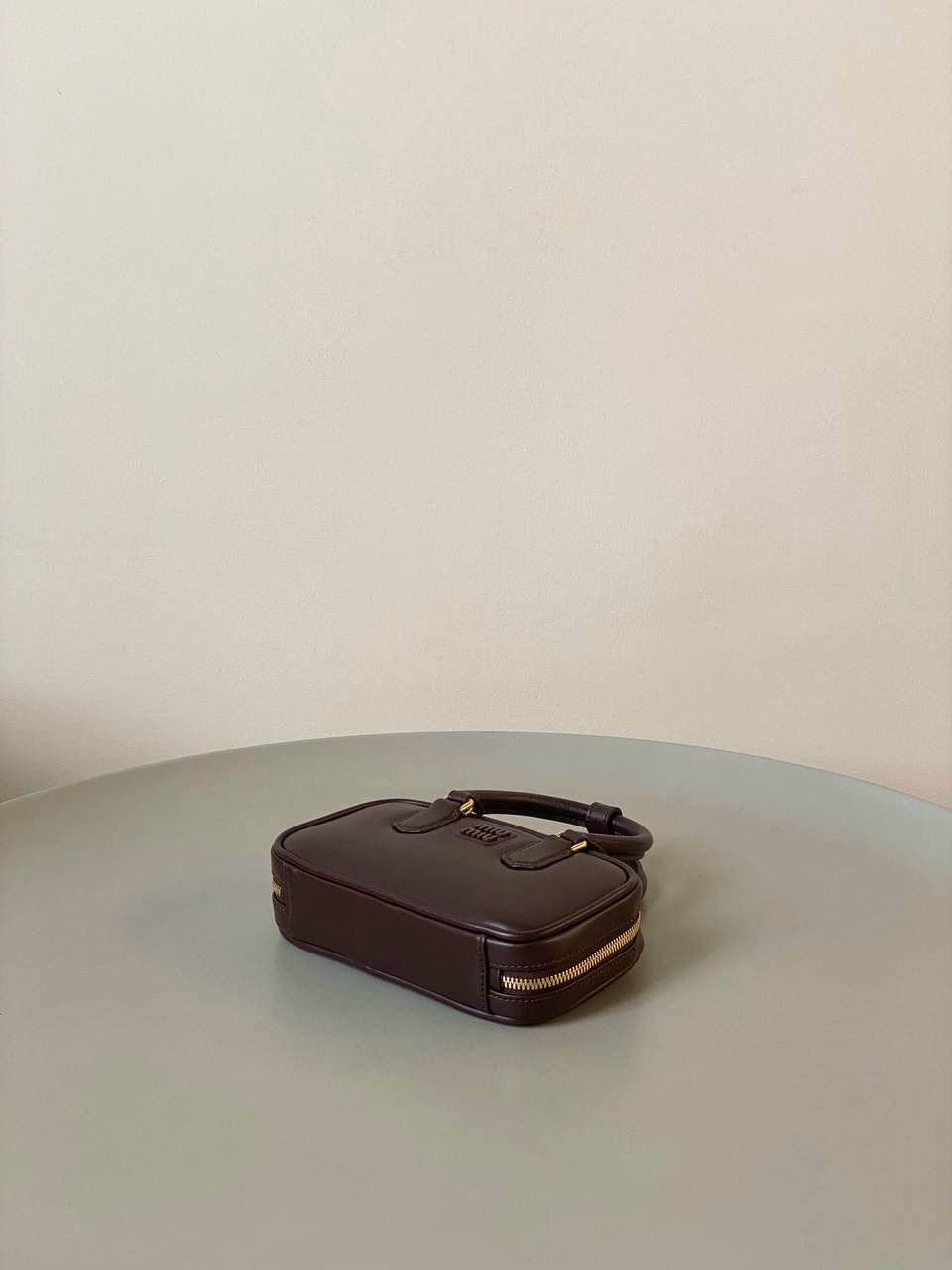 🈶石南木色，迷你 𝗠𝗶𝘂𝗠𝗶𝘂保龄球，大爆款 新尺寸也太可爱了！ 喜欢小包的姐妹这只必买！它要比小号小一些也窄一些 就巴掌大小，但容量还挺大的 装俩部手机都绰绰有余，日常够用 肩带长短也很ok，手拎斜挎都好看 反正放心冲就是了！拥有它，上班牛马的心情都会被治愈～ 迷你：19×10×5cm #F0011m 小号：22x10.5x7.5cm 大号：27x12x9cm