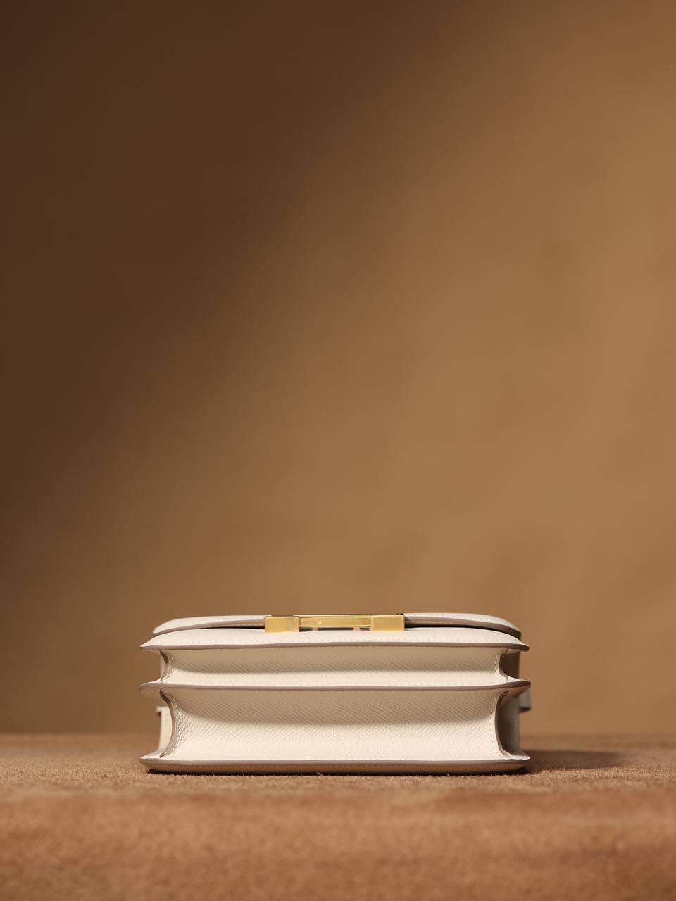 Hermes 爱马仕 #Constance 19奶昔白金扣👜✨ Epsom牛皮 单肩斜挎包 尺寸：19*15*4 cm 这款采用的是Epsom牛皮,纯原皮，和专柜用的是一个渠道的真皮 什么是Epsom牛皮？ 皮质：ep皮/手掌纹、一岁以上的公牛皮 软硬度：偏硬 纹理：皮面颗粒小的细腻皮纹，有点光泽感 特点：硬朗有细纹的牛皮皮质。细纹是进过后期处理的，比较硬质立体，长期贮存也不容易变形。自重轻，不易刮伤，非常耐磨实用。 所以每个H的款式用的皮都不一样，都是非常有讲究的✅