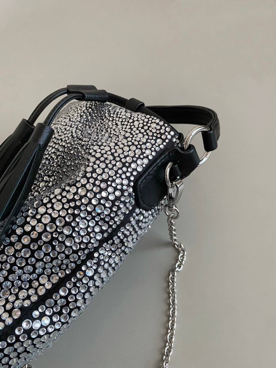 🈶钻石黑 𝗠𝗶𝘂𝗠𝗶𝘂满钻水桶包 blingbling的又是多少女生的心头爱 整个包身贴满水晶，搭配软绵绵的小羊皮， 在光线下非常闪✨不管是日常约会， 节日派对 晚宴都会是人群中的抢眼包 15×17×11cm F0053m