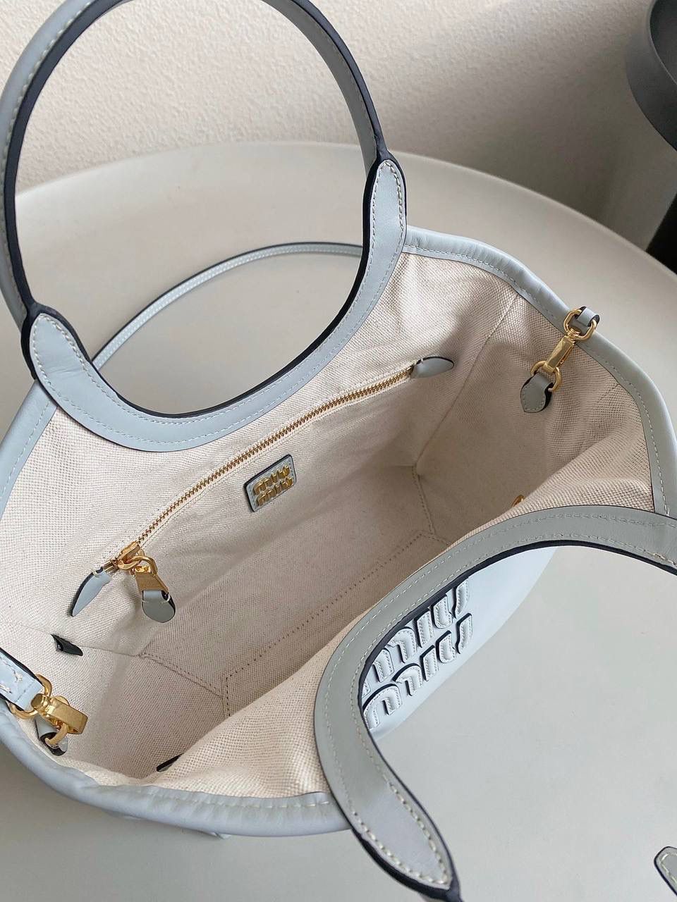 🈶冰蓝小号 𝗠𝗶𝘂𝗠𝗶𝘂托特！！ 近年miu家真的很会，都是心头爱 慵懒惬意的敞口托特搭配弧形包口 同色系浮雕logo低调又高级 软而不塌的全牛皮质感绝！ 中号大气的包身，男生女生都能驾驭 随时随地的凹造型 小号可以斜挎 小巧可爱，可太适合霓虹妹了 被痕痕拿捏住了🤙🏻 22×12×32cm #F0120m