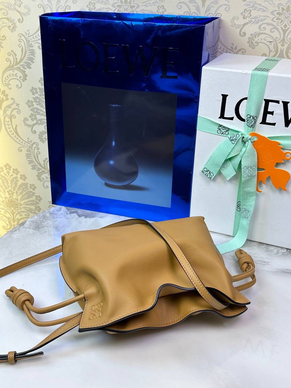 Flamenco clutch ✦迷你✦ 尺寸：𝟐𝟐.𝟓-𝟏𝟖-𝟗𝐜𝐦 型号：052030 棕色 ❤️mini flamenco clutch bag 可手拿亦可优雅斜挎 云朵般温暖亦轻盈的造型如此简单，💯耐看💯不会out的款式！ ❤️包袋采用进口小牛皮，手感如羊皮般细腻柔软，却比羊皮更加结实耐用，麂皮内衬 ❤️品牌标志性绳结设计，收紧袋口就是小福袋造型，超Q，看着不大实际超会装😇