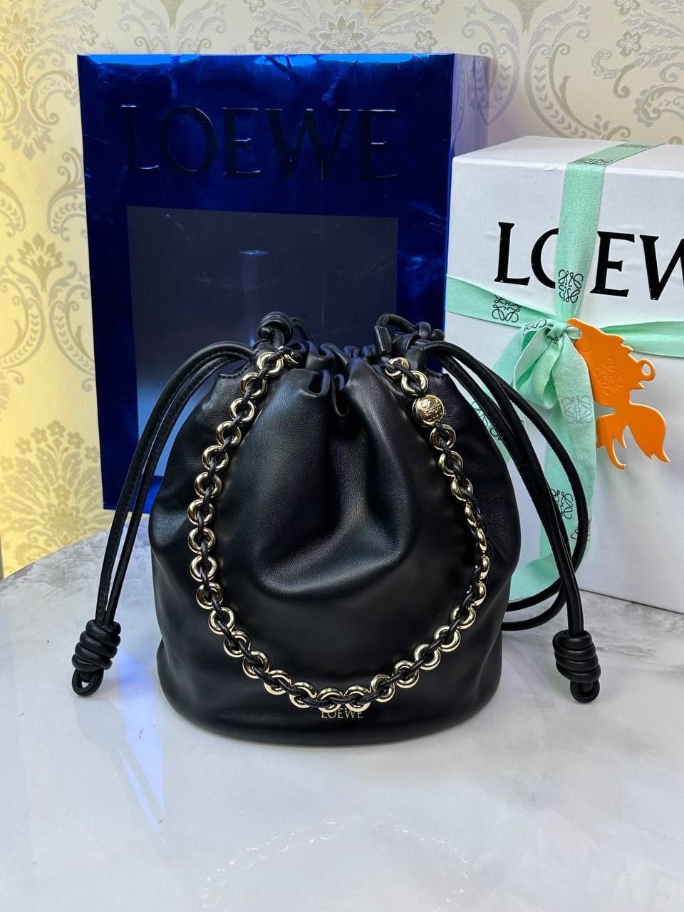 🎈链条款𝙁𝙡𝙖𝙢𝙚𝙣𝙘𝙤 𝙋𝙪𝙧𝙨𝙚水桶羊皮 ——【黑色】 尺寸：𝟑𝟐-𝟏𝟕-𝟐𝟒𝐜𝐦 编码：062406 👉🏻延续福袋收缩绳褶皱设计，全新推出水桶造型，羊皮包身手感细腻柔软❤️ 👉🏻链条肩带➕皮肩带的双肩带设计，时尚百搭，给足了集美们多样化的选择。肩带可拆卸可调节，磁扣开合，正面烫金𝙇𝙤𝙜𝙤，呈现出高贵典雅的视觉感😍 👉🏻独家背景➕独家品质➕独家全套砖柜礼盒套装，市场高端品质皆在我手✌🏻