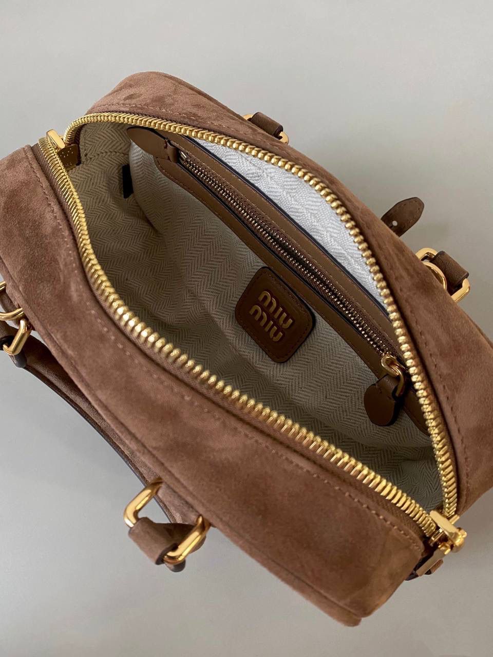 🈶可可棕，小号 𝗠𝗶𝘂𝗠𝗶𝘂24秋冬保龄球 今年棕麂皮系列大人气啊！深深的巧克力色，满满秋冬味儿～ 绒面皮每年都会有，但是！！今年这股风刮的特别猛 从秀场到ins博主穿搭，或者线上门店 几乎都有麂皮元素！ 西装款 夹克 风衣 鞋子 包括包包等 延续去年美拉德色系的颜色， 今年的颜色各种各样，有深有浅 但我唯爱咱miu家的这个巧棕色 绝对秋冬氛围感里，最“增质感”的时髦单品！ 小号：10.5×22×7.5cm #F0011m 大号：27x12x9cm