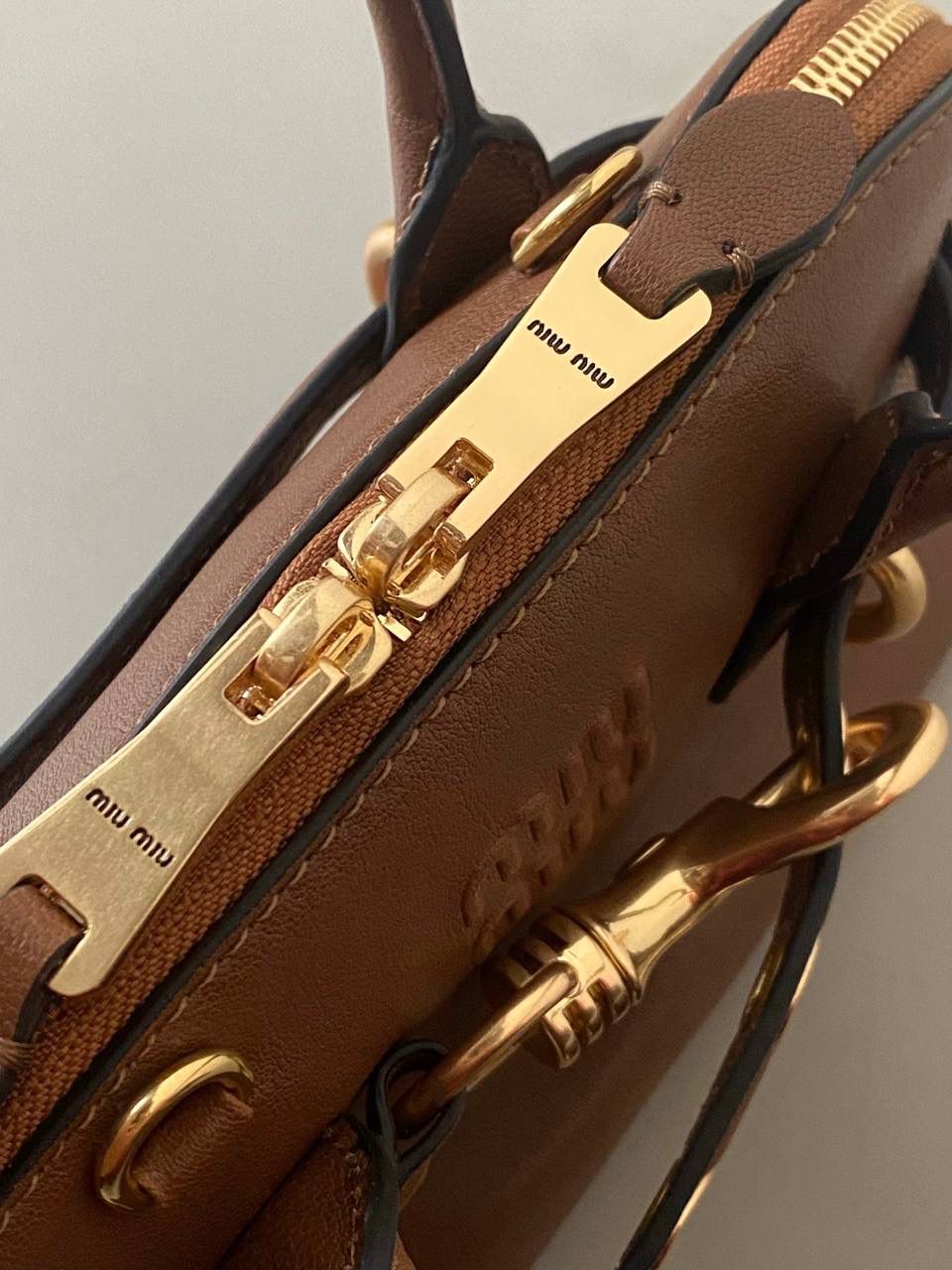 🈶焦糖色，迷你 𝗠𝗶𝘂𝗠𝗶𝘂24秋冬贝壳包 年度爆炸款来啦 | 真心被夸爆 没有过分夸张的设计，有着时髦且个性的圆弧包型，形似贝壳，看着很轻松又舒适一点也不会给人压力 双向拉链在保证实用性的同时让它充满了复古的调性，搭配上腰带式设计细节，时髦有态度 面料手感软糯，拎在手上可以切确感受到高级质感 迷你：8×13×21cm #F0022m 小号：16.5x28x10cm 大号：33x17x11cm