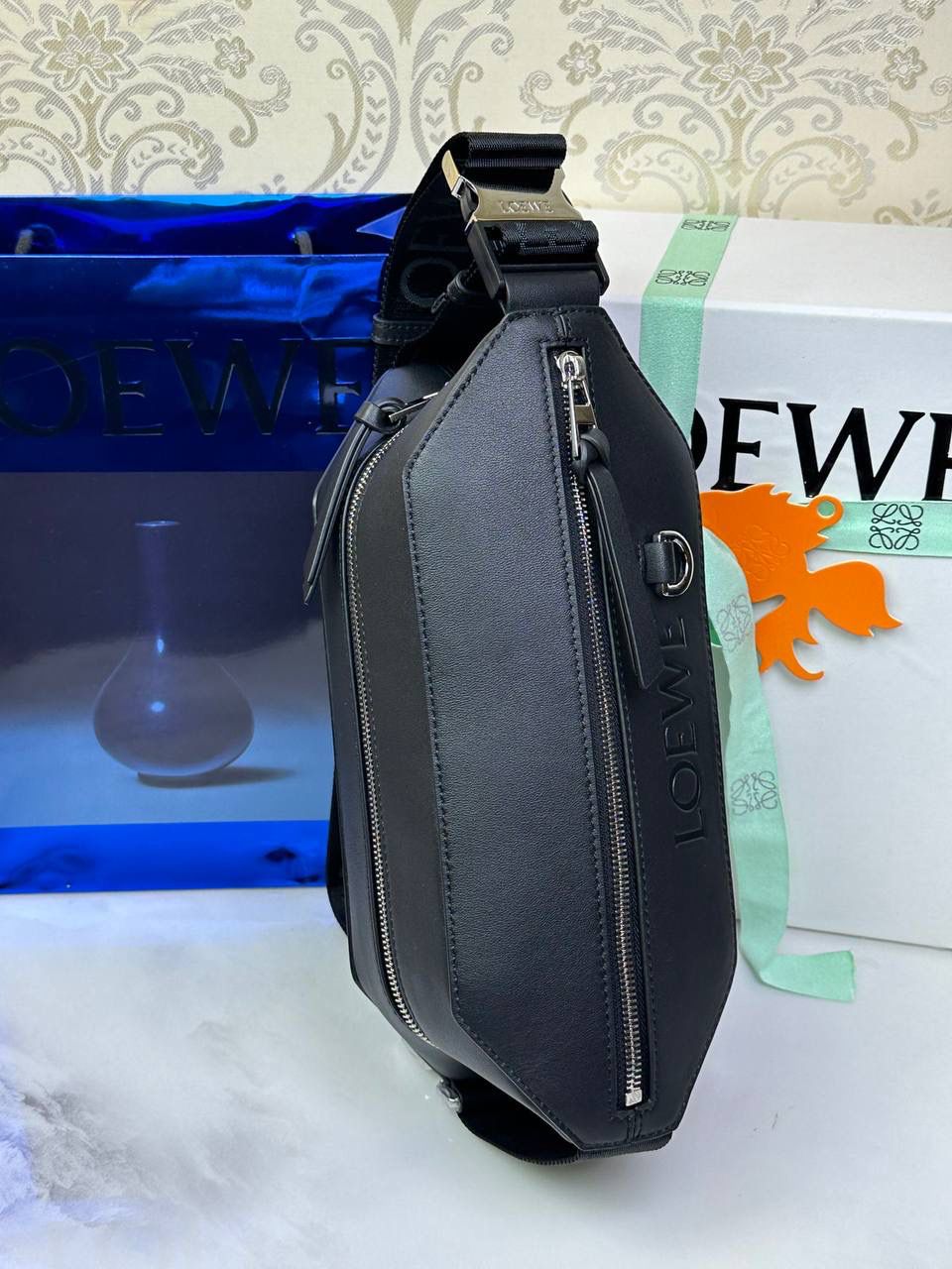 ———变形𝙎𝙡𝙞𝙣𝙜斜挎腰包👜 （新款黑色到货👉🏻） 尺寸：𝟑𝟐.𝟓-𝟗-𝟏𝟐.𝟑𝐜𝐦 编码：060402 👉🏻正面饰品牌标志性𝙇𝙤𝙜𝙤，搭配可调节𝙇𝙊𝙀𝙒𝙀织带，可打开以改变手袋容量并实现多种携带方式⭐️ 👉🏻经典小牛皮，皮质细腻柔软。可斜挎或者作为腰包携带，内里容量大，可容纳日常出行所需⭐️ 👉🏻独家全套礼盒套装➕独家高端品质，好货全在我手，送礼佳品⭐️