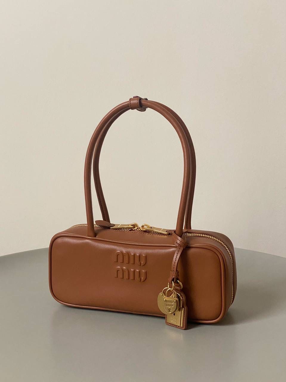 🈶干邑色 𝗠𝗶𝘂𝗠𝗶𝘂保龄球| 吊饰版 说是公文包.更是保龄球！ 虽倆者都早已大火全网时髦圈哈哈 今年这只长手柄保龄球能买到就是赚到咯！ 细长的手柄整体更秀气了 还送了一串吊饰 是一把锁头还有一个爱心， 上面都有logo刻印很精致也很厚重 宝子们再也不愁买挂饰啦！ 28×11.5×8cm #F0010m