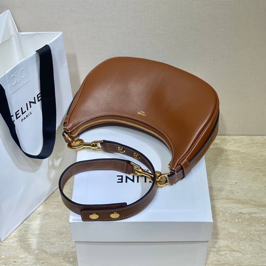 🔥大货实拍图 𝗖𝗘𝗟𝗜𝗡𝗘 ♥ 𝗔𝗩𝗔 𝗦𝗧𝗥𝗔𝗣 独特新月包型打造摩登格调，醒目金属圆环与考究皮革饰带点缀，匠心与巧思交织，定格别致意趣造型。型号：196923 尺寸：24*13*7cm