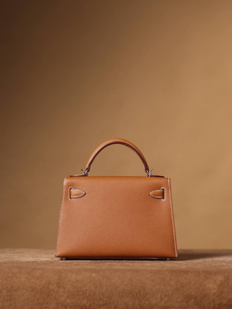 HERMES 爱马仕 Mini Kelly 二代👜✨ Mini Kelly 二代 金棕银扣 高清实拍图 尺寸：19*12*6cm Hermès爱马仕是世界著名的奢侈品品牌，1837年由Thierry Hermès创立于法国巴黎。 爱马仕早年以制造高级马具起家，迄今已有180年的悠久历史。 其整个品牌从整体到细节以及专卖店，都弥漫着浓郁的以马文化为中心的深厚底蕴🎀