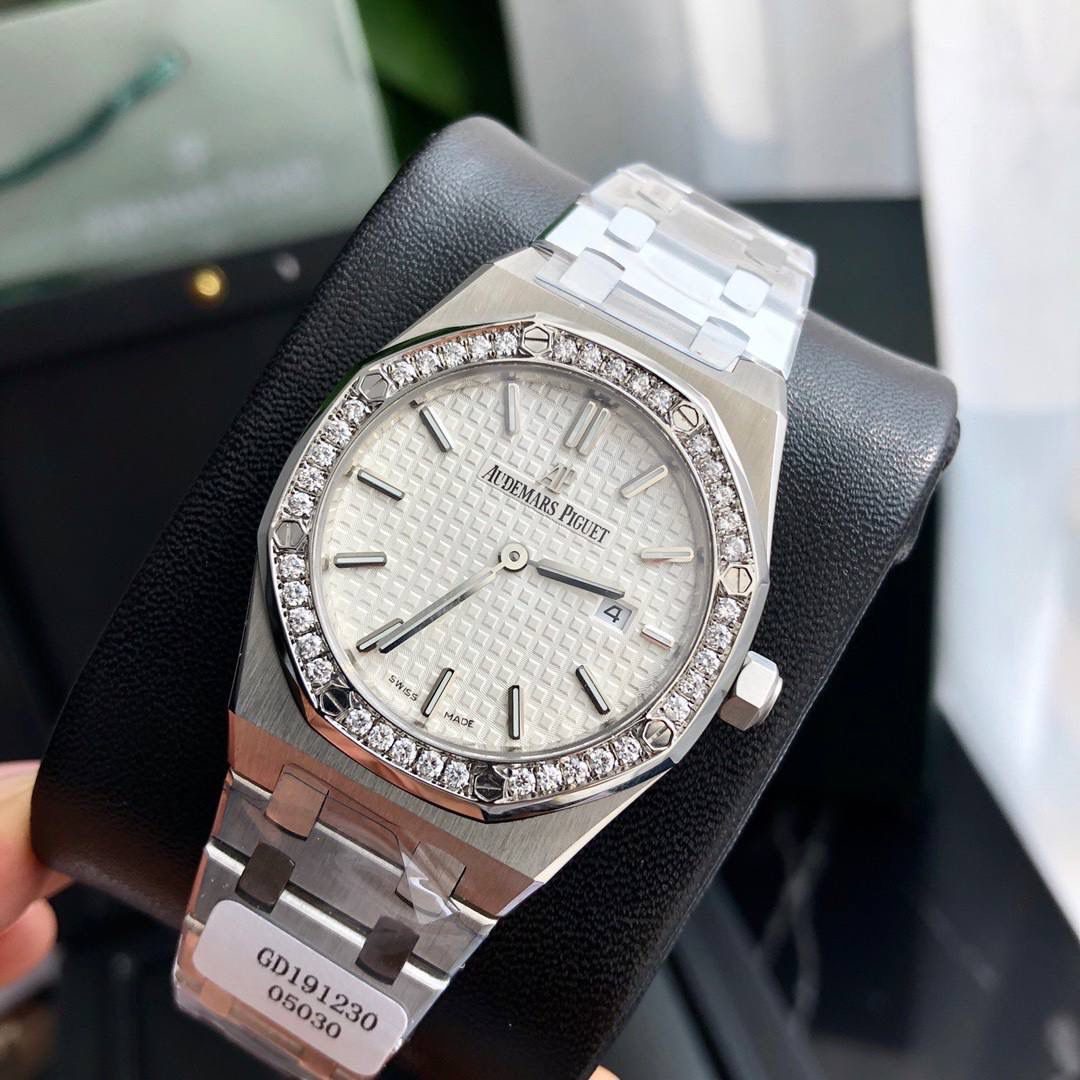 专柜很难买的AP女款到货啦！今天我们介绍的就是爱彼皇家橡树系列中的女士腕表。其官方型号为67651ST.ZZ.1261ST.01。爱彼皇家橡树系列独有的八角形外观还拥有爱彼独特的设计风格也将女士优雅风格融入其中，深受女士们的爱戴，即使只有33毫米的小尺寸，也将爱彼独有的纯净美感与刚毅线条展现的淋漓尽致。 而镶满钻石的表圈也为佩戴的女士增添了更多的柔美。（40颗明亮型切割美钻 总重约0.71克拉）搭载瑞士石英机芯、拥有实用的日历显示功能，女士们佩戴起来不会显得沉重 配专柜全套包装出售。这种货一般数量不是很多的。数量有限哦。