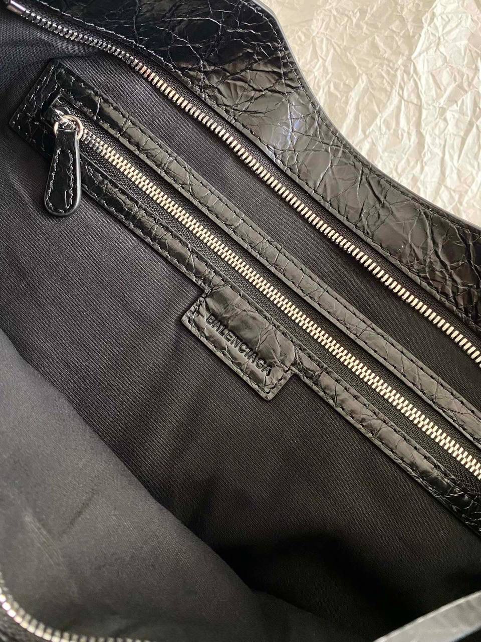 爆款🔥再次回货❗️ ba1enciaga lie city机车包中号 黑银🖤 24款比中古款有几处变化 肩带变得更干净利落，不累赘 底部的铆钉也去了，也是可以给包身减重 拉牌也全都换成了流苏～显得更流浪不羁了 机车包最有灵魂的就是它的皮料 皮纹够丰富，皮质够柔韧 一定要用原厂皮才能做出最高的还原度 认准我们家，只做原厂皮⚠️ 38.5×24×13.5cm797786m