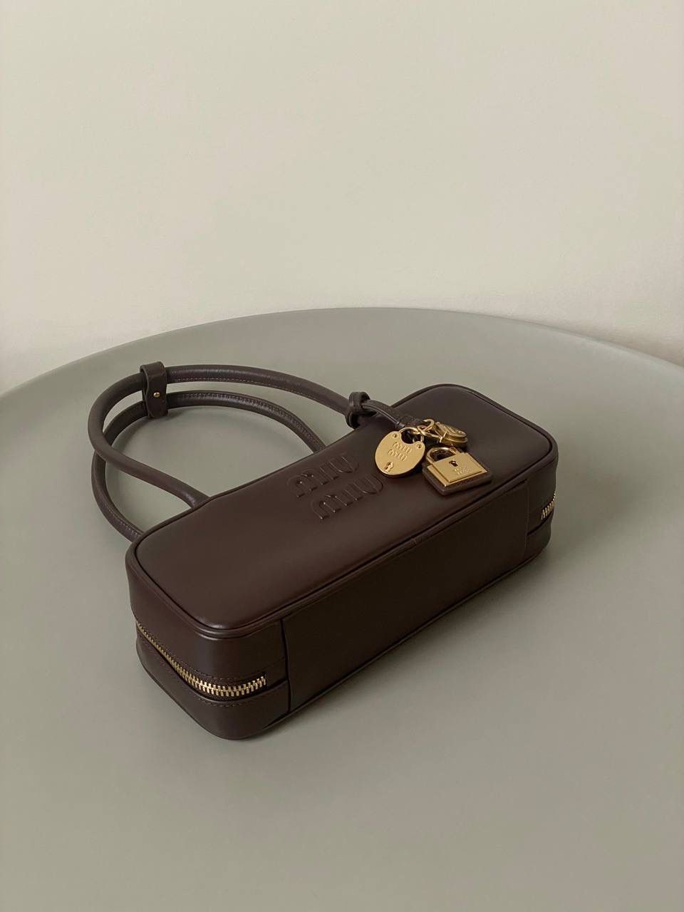 🈶石南木色 𝗠𝗶𝘂𝗠𝗶𝘂保龄球| 吊饰版 说是公文包.更是保龄球！ 虽倆者都早已大火全网时髦圈哈哈 今年这只长手柄保龄球能买到就是赚到咯！ 细长的手柄整体更秀气了 还送了一串吊饰 是一把锁头还有一个爱心， 上面都有logo刻印很精致也很厚重 宝子们再也不愁买挂饰啦！ 28×11.5×8cm #F0010m