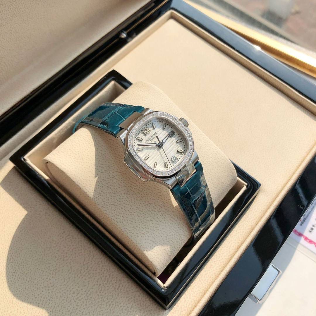 堪称一绝钢表之王，最美女款百达翡丽7010R鹦鹉螺 32mm银色蓝白色 表徑精巧独特舷窗结构表壳，完美优雅风格，采用不锈钢18k镀玫瑰金。水平横纹浮雕图案的表盘。表圈镶嵌46颗天然南非钻石💎美洲鳄鱼皮表带‼️