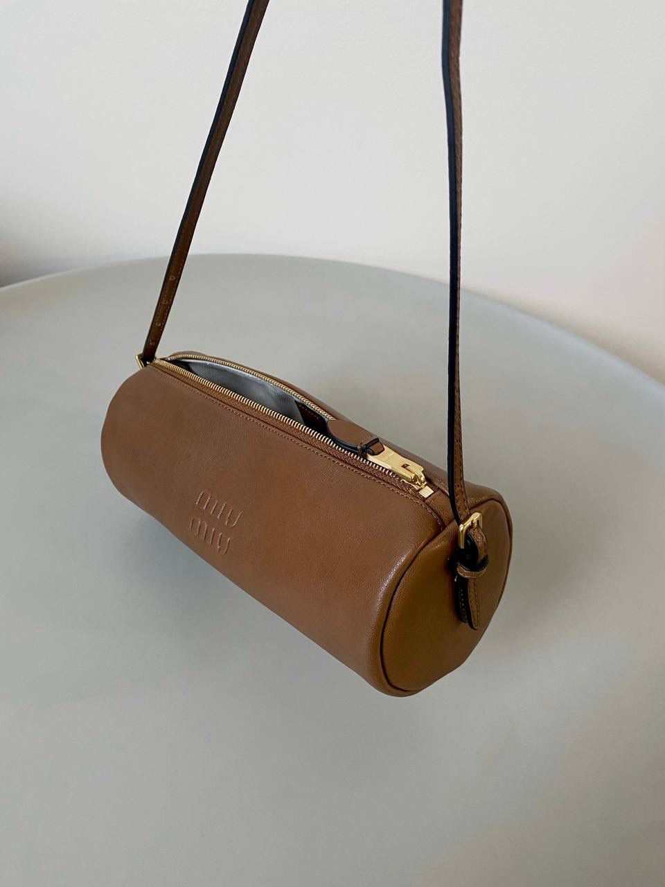 🈶焦糖色 𝗠𝗶𝘂𝗠𝗶𝘂迷你小圆筒 小小一只，太可爱了啦！ 头层Nappa(纳帕)羊皮用料 柔软细腻有光泽，透出高级的质感 整个包都好软糯手感超治愈的！！ 自重非常非常轻！日常还能装不少 肩带长度可以调，冬天大衣能轻松驾驭 小包闭眼冲就是了，四季可用 21.5×9×9cm #F0055m