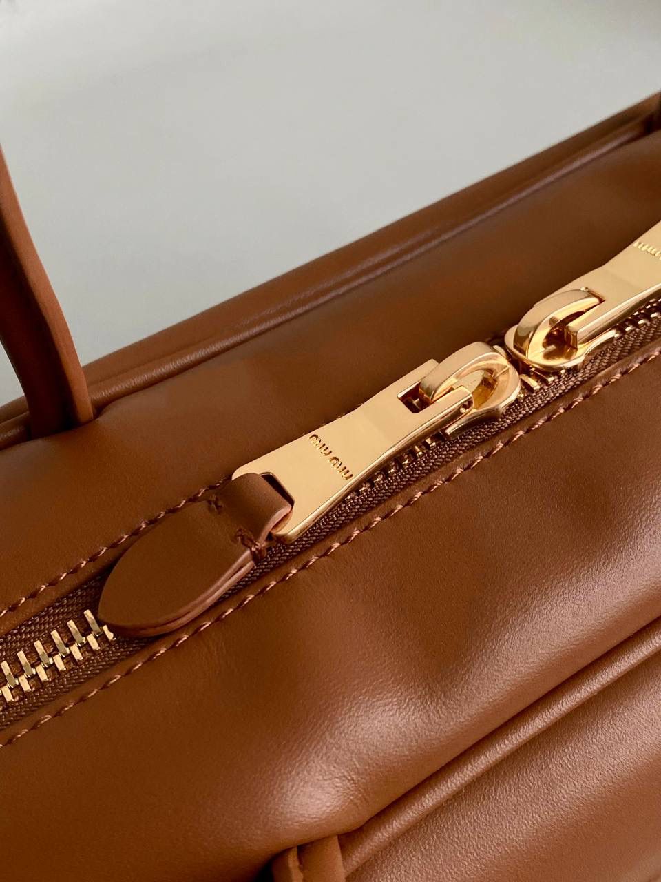 🈶焦糖色 | 无肩带款 𝗠𝗶𝘂𝗠𝗶𝘂爆款公文包 嗯！最新版的第三代最时尚、 虽没有肩带但变长后的手柄反而更优秀了，有种松弛的时髦感 看似一样，实际尺寸上有轻微小改 但差异不大，整体比老款要厚一点点 依然能装 自重轻，长柄能肩背不要太香 近两年miu水涨船高，爆款制造机 出什么火什么，杀疯了已经，都去冲 一整个甜酷少女感路线，赢麻了！！ 23×34×12cm #F0020m