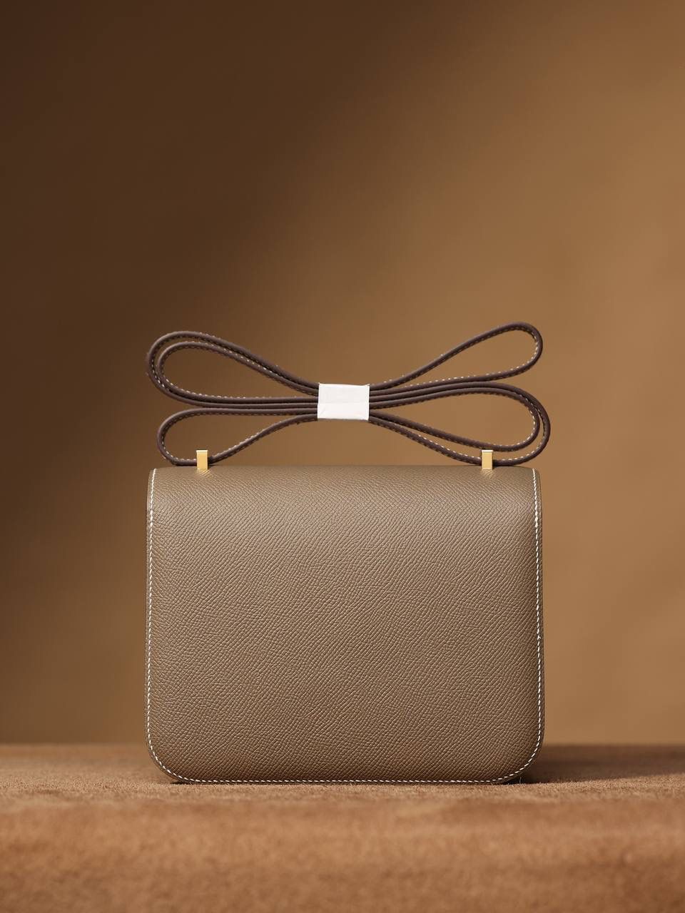 Hermes 爱马仕 #Constance 19大象灰 金扣👜✨ Epsom牛皮 单肩斜挎包 尺寸：19*15*4 cm 这款采用的是Epsom牛皮,纯原皮，和专柜用的是一个渠道的真皮 什么是Epsom牛皮？ 皮质：ep皮/手掌纹、一岁以上的公牛皮 软硬度：偏硬 纹理：皮面颗粒小的细腻皮纹，有点光泽感 特点：硬朗有细纹的牛皮皮质。细纹是进过后期处理的，比较硬质立体，长期贮存也不容易变形。自重轻，不易刮伤，非常耐磨实用。 所以每个H的款式用的皮都不一样，都是非常有讲究的✅
