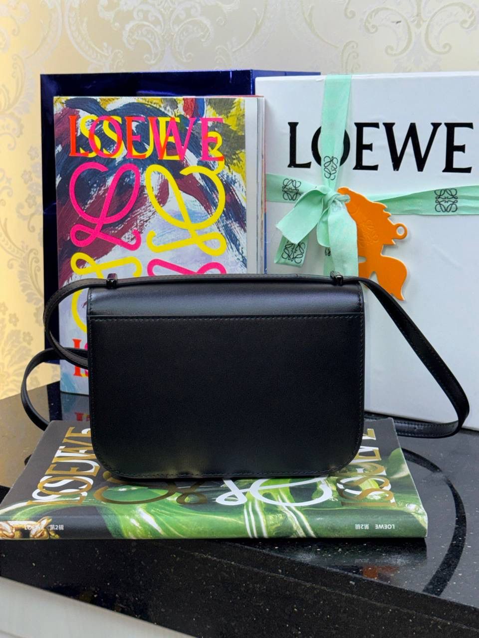 🎈单色釉𝘎𝘰𝘺𝘢*缎面皮 —【黑色到货✅】 尺寸：𝟏𝟗-𝟔-𝟏𝟑.𝟓𝐜𝐦 编码：262123 【配全套礼盒】 ✅汲取古代单色釉瓷器色彩灵感，全新打造𝘓𝘰𝘸𝘦*单色釉系列。该款采用缎面丝绸牛皮搭配内里纳帕羊皮，手感丝滑细腻。正面立体膨胀𝘈𝘯𝘨𝘳𝘢𝘮 𝘓𝘰𝘨𝘰设计搭配陶瓷小兔子挂饰，堪称时尚界的艺术品。 ✅磁扣开合，内部3个隔层设计，以及按扣和背面小侧袋，收纳方便➕安全感满分，能装，好搭。