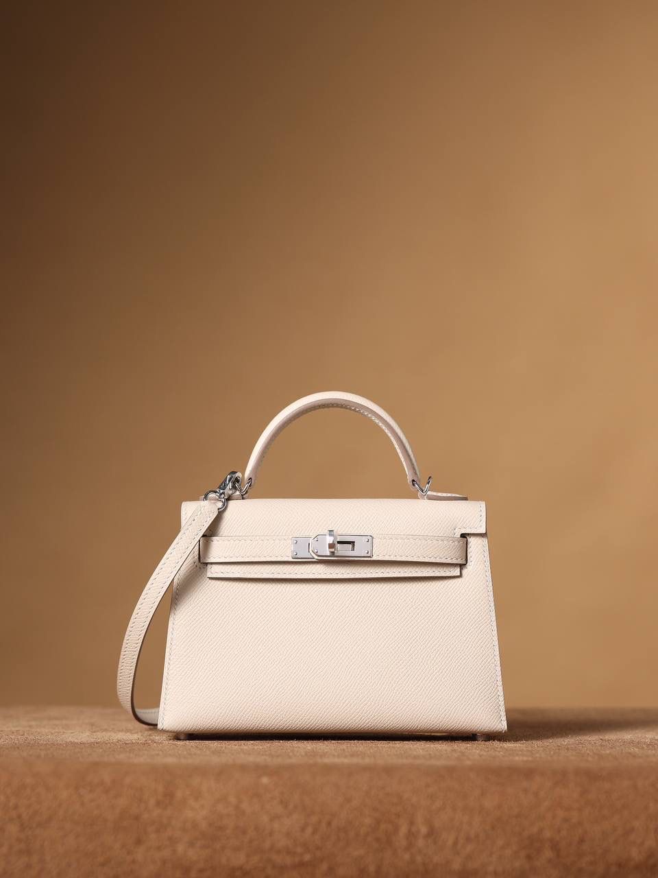 HERMES 爱马仕 Mini Kelly 二代 👜✨ Mini Kelly 二代 奶昔白银扣 高清实拍图 尺寸：19*12*6cm Hermès爱马仕是世界著名的奢侈品品牌，1837年由Thierry Hermès创立于法国巴黎。爱马仕早年以制造高级马具起家，迄今已有180年的悠久历史。 其整个品牌从整体到细节以及专卖店，都弥漫着浓郁的以马文化为中心的深厚底蕴🎀