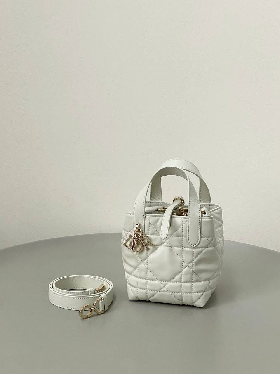 🈶白色，迷你 𝗗𝗜𝗢𝗥 𝗧𝗼𝘂𝗷𝗼𝘂𝗿𝘀新版竖款 火爆全网toujours缩小版来啦！ 看到真的心动得不行～ 实物就是常规迷你水桶大小， 真的可爱死 别说，包虽小但容量还挺大的 日常用品都能轻松装上 肩带长度也刚刚好，不挑身高 反正就是太乖啦！夏日必备 😍 13×15×12cm #M1272m