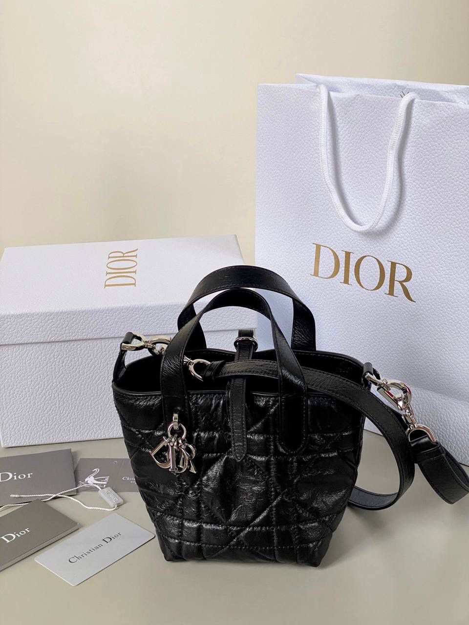 🈶油蜡黑，迷你 𝗗𝗜𝗢𝗥 𝗧𝗼𝘂𝗷𝗼𝘂𝗿𝘀新版竖款 火爆全网toujours缩小版来啦！ 看到真的心动得不行～ 实物就是常规迷你水桶大小， 真的可爱死 别说，包虽小但容量还挺大的 日常用品都能轻松装上 肩带长度也刚刚好，不挑身高 反正就是太乖啦！夏日必备 😍 13×15×12cm #M1272m