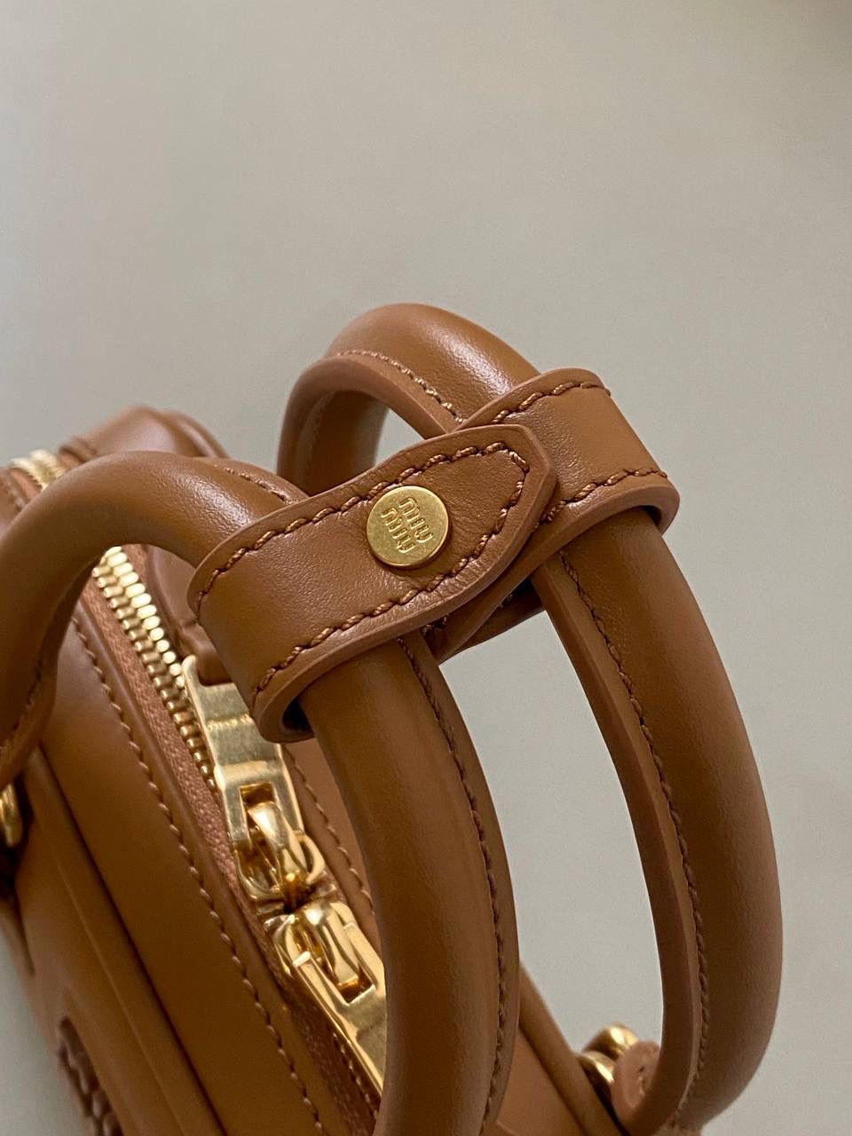 🈶干邑色，迷你 𝗠𝗶𝘂𝗠𝗶𝘂保龄球，大爆款 新尺寸也太可爱了！ 喜欢小包的姐妹这只必买！它要比小号小一些也窄一些 就巴掌大小，但容量还挺大的 装俩部手机都绰绰有余，日常够用 肩带长短也很ok，手拎斜挎都好看 反正放心冲就是了！拥有它，上班牛马的心情都会被治愈～ 迷你：19×10×5cm #F0011m 小号：22x10.5x7.5cm 大号：27x12x9cm