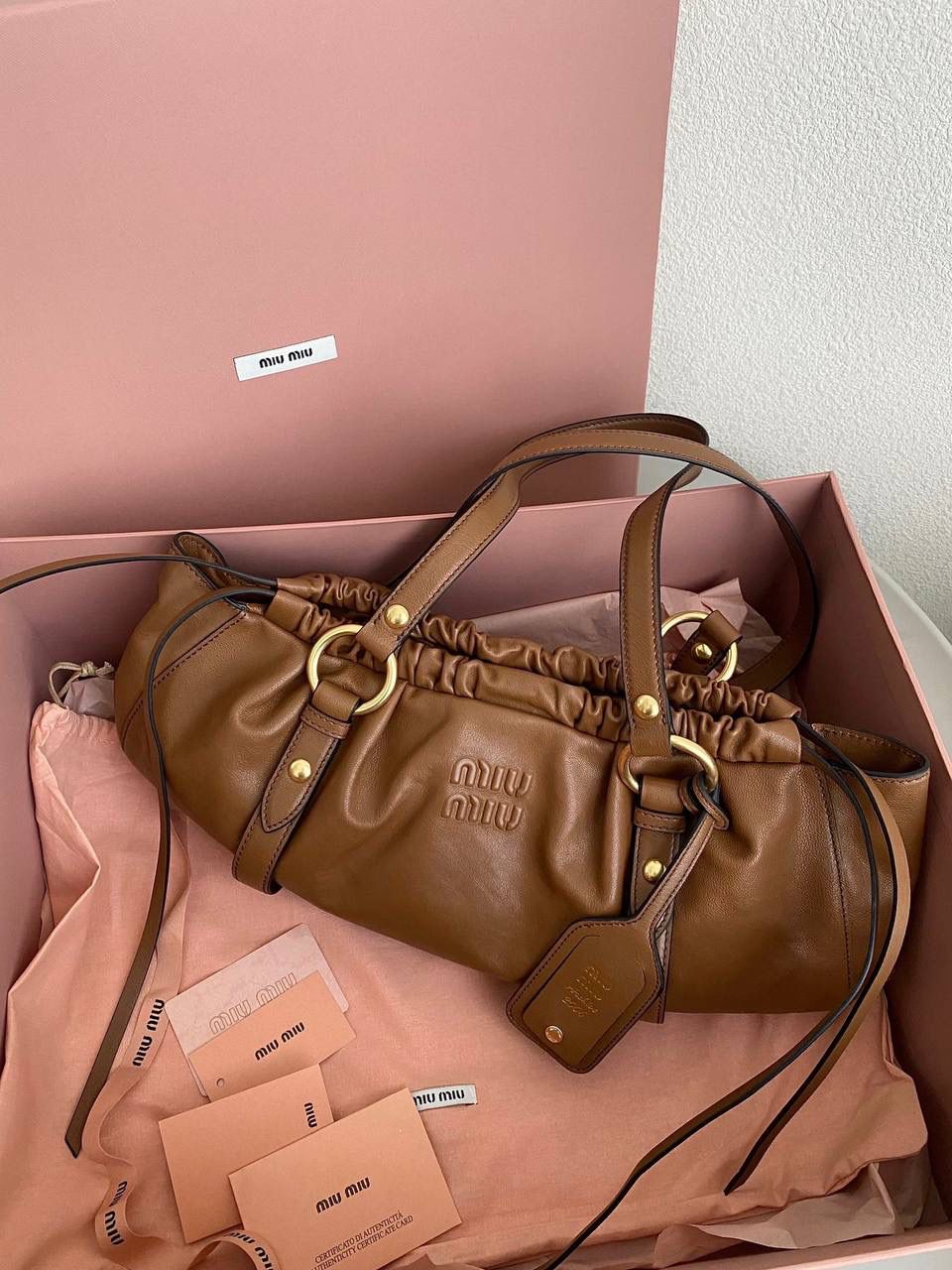 🈶焦糖色 𝗠𝗶𝘂𝗠𝗶𝘂 𝗡𝗮𝗽𝗽𝗮 饺子包 这只亮点在于包口用的是抽绳束口！ 抽绳可以随意调节，搭配的纤长双手柄可肩背或手提也可以随意捧在腰际'柔软的皮质加上不定型的设计，慵懒随性的调调一下就出来了 满满的vintgge复古感，既叛逆又不失格调'好喜欢啊 16×44×10.5cm #F0016m