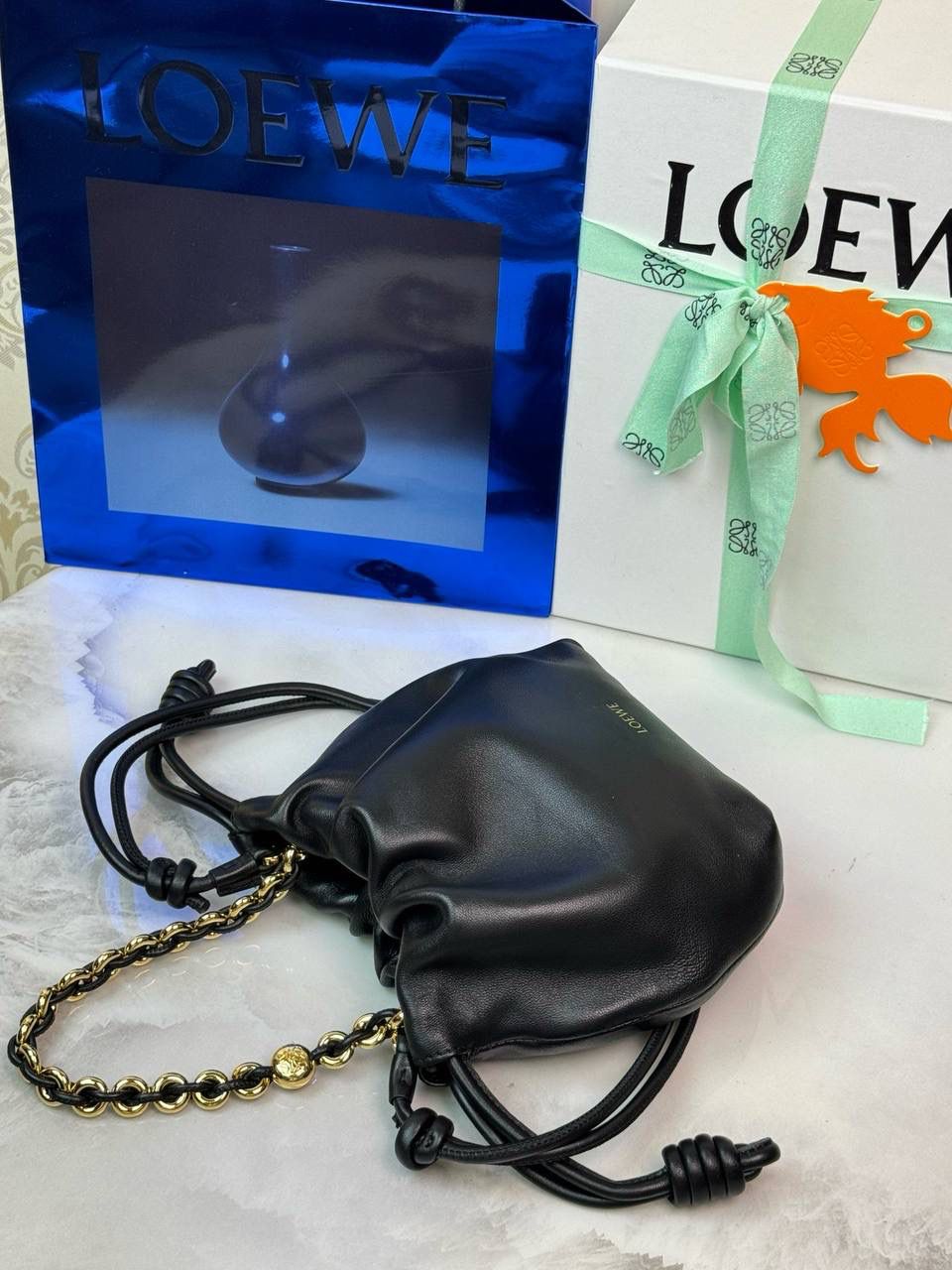🎈迷你链条款𝙁𝙡𝙖𝙢𝙚𝙣𝙘𝙤 𝙋𝙪𝙧𝙨𝙚羊皮 ——【黑色】 尺寸：𝟐𝟑.𝟓-𝟓-𝟏𝟕𝐜𝐦 编码：062347 👉🏻延续福袋收缩绳褶皱设计，羊皮包身手感细腻柔软❤️ 👉🏻链条肩带➕皮肩带的双肩带设计，时尚百搭，给足了集美们多样化的选择。肩带可拆卸可调节，磁扣开合，正面烫金𝙇𝙤𝙜𝙤，呈现出高贵典雅的视觉感😍 👉🏻独家背景➕独家品质➕独家全套砖柜礼盒套装，市场高端品质皆在我手✌🏻