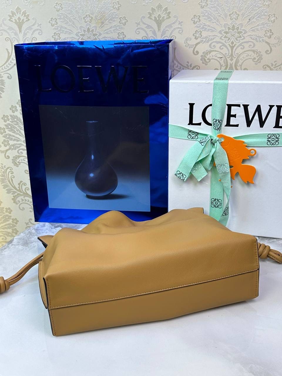 Flamenco clutch✦中号✦ 尺寸：𝟑𝟎-𝟐𝟒.𝟓-𝟏𝟎.𝟓𝐜𝐦 型号：052028 棕色 ❤️flamenco clutch bag可手拿亦可优雅斜挎 云朵般温暖亦轻盈的造型如此简单，💯耐看💯不会out的款式！ ❤️包袋采用进口小牛皮，手感如羊皮般细腻柔软，却比羊皮更加结实耐用，麂皮内衬 ❤️品牌标志性绳结设计，收紧袋口就是小福袋造型，超Q，看着不大实际超会装😇