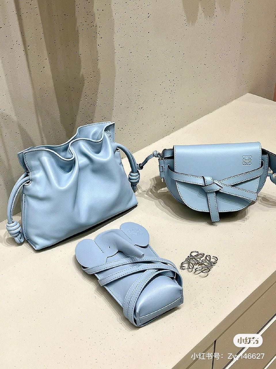 Flamenco clutch-NEW ✦迷你✦ 尺寸：𝟐𝟐.𝟓-𝟏𝟖-𝟗𝐜𝐦 型号：052030灰蓝色 ❤️mini flamenco clutch bag 可手拿亦可优雅斜挎 云朵般温暖亦轻盈的造型如此简单，💯耐看💯不会out的款式！ ❤️包袋采用进口小牛皮，手感如羊皮般细腻柔软，却比羊皮更加结实耐用，麂皮内衬 ❤️品牌标志性绳结设计，收紧袋口就是小福袋造型，超Q，看着不大实际超会装😇