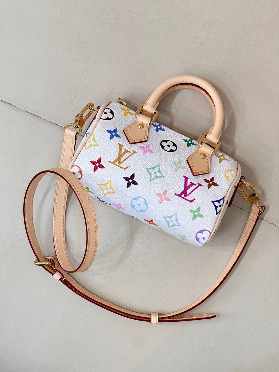LV村上隆联名白三彩Nano Speedy来啦！姐妹们快看这个神仙包包！👜🌈 白色打底+彩色老花图案，配上祖传小锁头钥匙包，简直是《Mean Girls》千禧辣妹的标配！全新数码印花绝绝子，太阳花和熊猫都像要跳出来，阳光下自带ins滤镜特效！别看它巴掌大，手机口红💄钥匙全塞得下，从此打脸那些说mini包不实用的人！ 尺寸：16-10-7.5cm