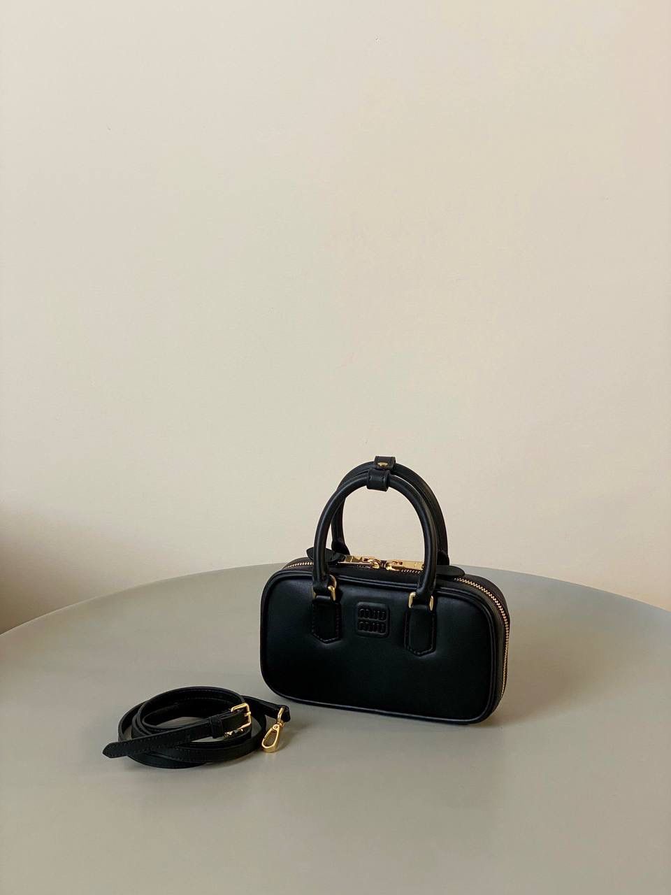 🈶黑色，迷你 𝗠𝗶𝘂𝗠𝗶𝘂保龄球，大爆款 新尺寸也太可爱了！ 喜欢小包的姐妹这只必买！它要比小号小一些也窄一些 就巴掌大小，但容量还挺大的 装俩部手机都绰绰有余，日常够用 肩带长短也很ok，手拎斜挎都好看 反正放心冲就是了！拥有它，上班牛马的心情都会被治愈～ 迷你：19×10×5cm #F0011m 小号：22x10.5x7.5cm 大号：27x12x9cm