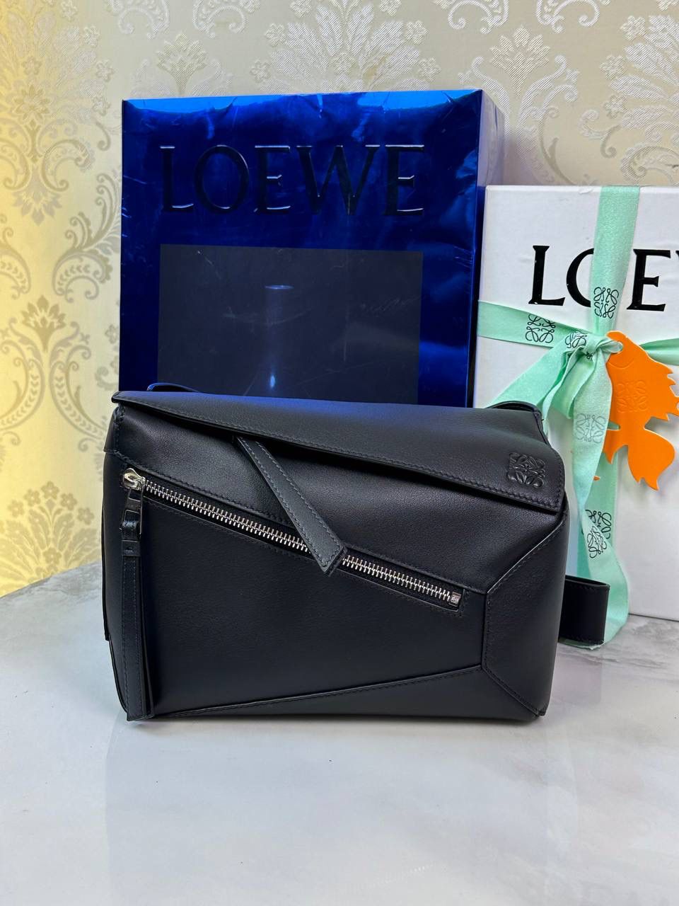 ⭐️最新升级版𝟮.𝟬-𝗣𝘂𝘇𝘇𝗹𝗲腰包⭐️ （黑色 到货‼️） 尺寸：𝟮𝟰-𝟭𝟬.𝟱-𝟭𝟲𝗰𝗺 款号：052343 👉🏻长方体形状和精确的切割技巧创造出Puzzle 腰包以及独特的几何线条成为 “Loe罗家”的著名代表作~ 👉🏻金属搭扣开合，刻有标志logo徽标，可调节肩带，翻盖大容量插袋和一个外部拉链口袋，🐂柔软细腻napa小牛皮，正品Ykk五金，Anagram压纹，人字纹棉麻帆布内里 👉🏻（男女♀♂同款）大小非常合适。胸包、背包、单肩、斜挎 腰包五种背法任你解锁🔒 👉🏻 （独家背景➕独家品质➕独家包装➕独家控制对版细节📦➕精致全套礼盒套装❤️） 重点：让你花最少的钱💰体验最大的仪式感❤️