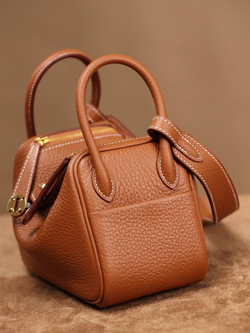 Hermes 爱马仕 Lindy Mini 19cm 金棕色金扣👜✨ Lindy 独家渠道货 独家欧洲原厂皮原厂五金组装的ZP尾单货 尺寸：19*12.5*9cm Lindy是采用原厂的正品TC皮，什么是TC皮？ 爱马仕专用的clemence,简称tc皮，是Hermes最受欢迎的皮革之一，颜色会比Togo少一些，但是纹路比Togo细腻，含油更高，更软，因此稍稍有些下垂感的特点。