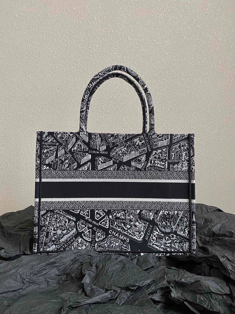 🈶黑色中号 𝗖𝗗 𝗕𝗼𝗼𝗸 𝗧𝗼𝘁𝗲 23夏季"巴黎地图"🖤 说实话，近年来花卉系列有点看乏看腻的 请你们一定看看这一只，新的炙热款！！ 本季主打的巴黎第八街区地图，惊艳了全网 真真实实绣在整个包上，砖柜超级难抢的！ 黑白色调干净利落，复古又神秘的法式浪漫 那种高定视觉，沦陷了！沦陷了！ 行走的巴黎街头很是时髦，我先冲了！😍😍 36×27×16cm