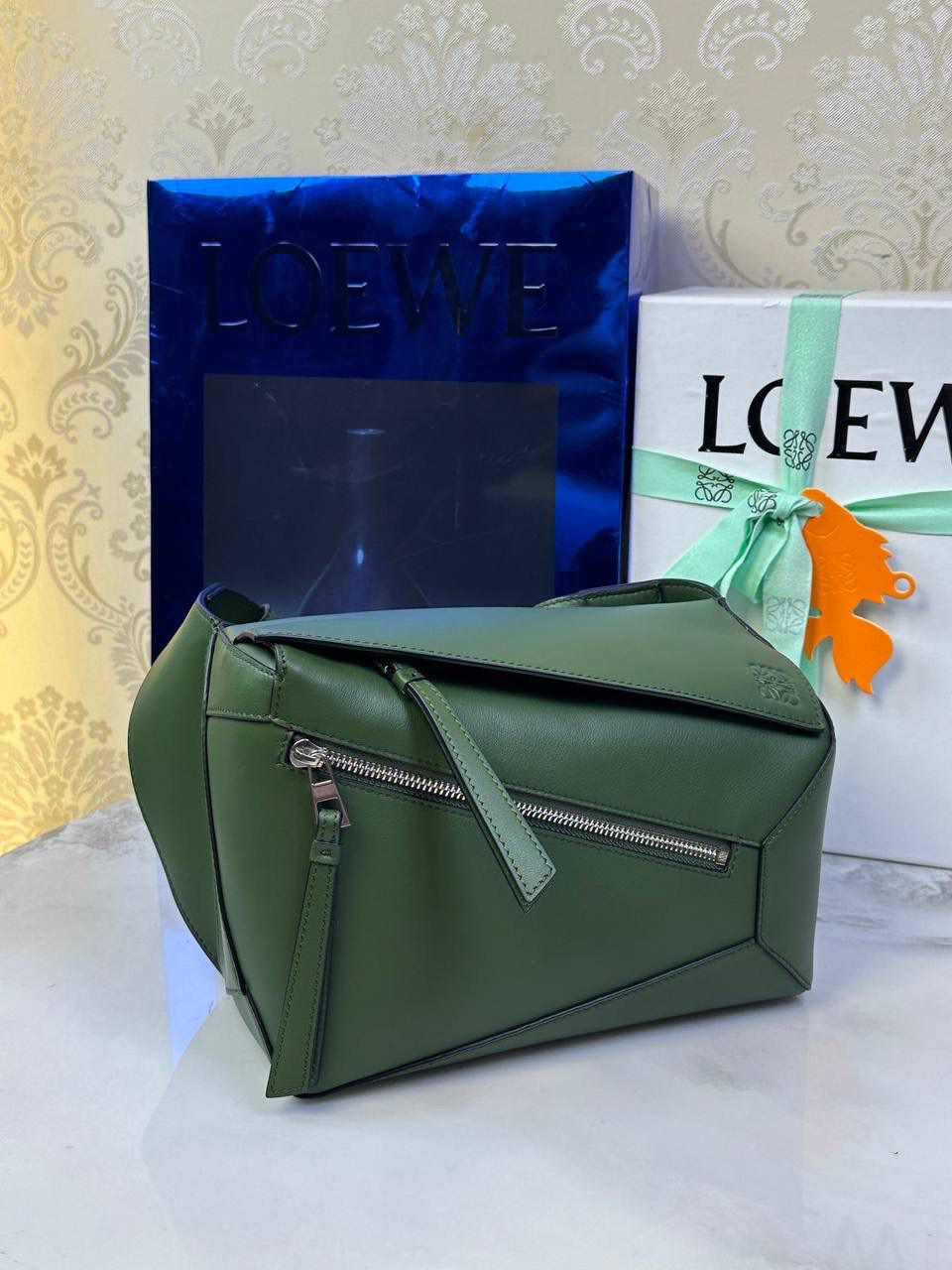 ⭐️最新升级版𝟮.𝟬-𝗣𝘂𝘇𝘇𝗹𝗲腰包⭐️ （森林绿🌳到货‼️） 尺寸：𝟮𝟰-𝟭𝟬.𝟱-𝟭𝟲𝗰𝗺 款号：052343 👉🏻长方体形状和精确的切割技巧创造出Puzzle 腰包以及独特的几何线条成为 “Loe罗家”的著名代表作~ 👉🏻金属搭扣开合，刻有标志logo徽标，可调节肩带，翻盖大容量插袋和一个外部拉链口袋，🐂柔软细腻napa小牛皮，正品Ykk五金，Anagram压纹，人字纹棉麻帆布内里 👉🏻（男女♀♂同款）大小非常合适。胸包、背包、单肩、斜挎 腰包五种背法任你解锁🔒 👉🏻 （独家背景➕独家品质➕独家包装➕独家控制对版细节📦➕精致全套礼盒套装❤️） 重点：让你花最少的钱💰体验最大的仪式感❤️