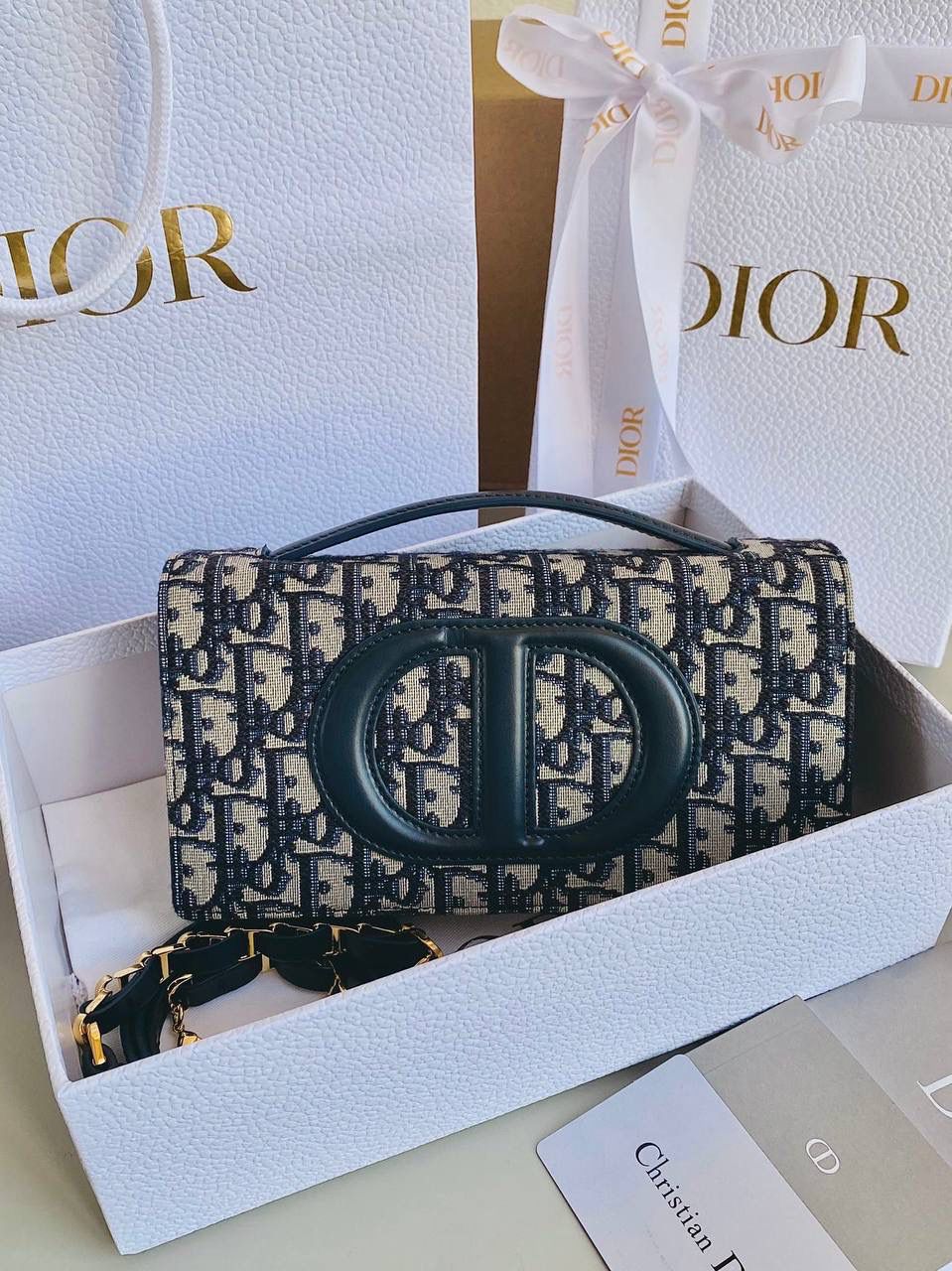 🈶老花蓝 𝗗𝗜𝗢𝗥 𝗦𝗶𝗴𝗻𝗮𝘁𝘂𝗿𝗲 链条手袋 全新系列一出直接萌翻天，很难不火 通常在金属包扣或链条装饰的CD字母 这次当了回主角，直接放大像极了猪鼻子 压印浮雕质感和字母的立体弧度，好高级 成了包身上一眼就能看到的重点元素 女生风格多面，包包更是如此 当一只小可爱不仅可以斜挎单肩 还能拎着当手拿包，搭配丝巾腋下背 基本就已经被拿捏住了！！ 翻盖开合像个小盒子，日常通勤容量OK 21×11×5cm，#8133m