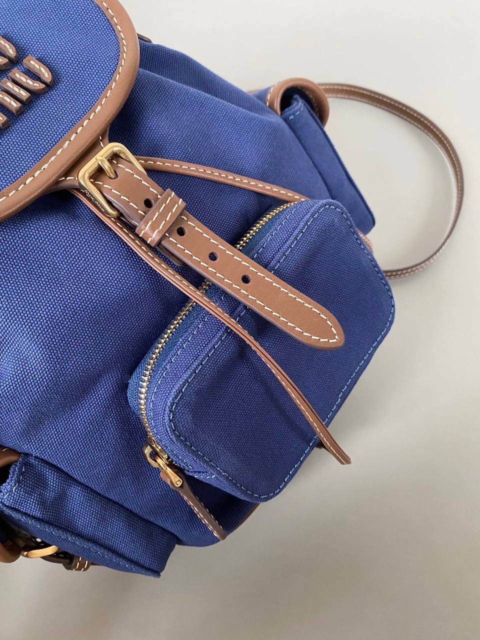 🈶帆布蓝，小号 𝐌𝐢𝐮𝐌𝐢𝐮 双肩包 喔噻！缪缪终于出双肩包了！ 超级经典的款，配色也是无敌了 多个口袋设计非常复古学院风，青春洋溢！ 五金质感超绝，带有微微做旧的复古磨砂感 这种材质耐用度极高 帆布版俩个颜色都好看！海军蓝，甜酷不失高级感 总的来说夏天就是要拿个亮色的出游 轻便实用 小号：18×22×11.5cm #F0060m 大号：25x29x12.5cm