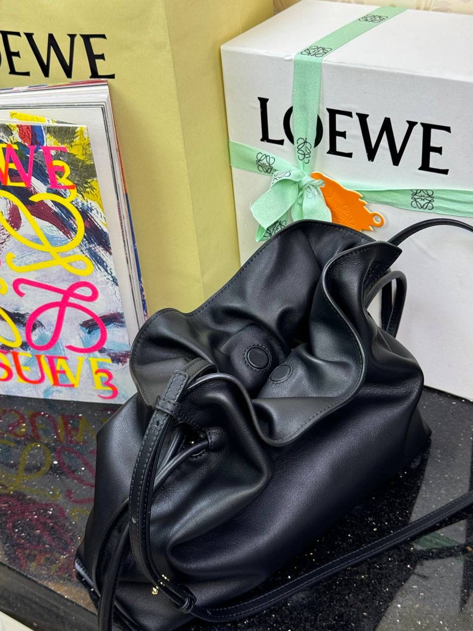 Flamenco clutch✦中号✦ 尺寸：𝟑𝟎-𝟐𝟒.𝟓-𝟏𝟎.𝟓𝐜𝐦 型号：052028黑色 ❤️flamenco clutch bag可手拿亦可优雅斜挎 云朵般温暖亦轻盈的造型如此简单，💯耐看💯不会out的款式！ ❤️包袋采用进口小牛皮，手感如羊皮般细腻柔软，却比羊皮更加结实耐用，麂皮内衬 ❤️品牌标志性绳结设计，收紧袋口就是小福袋造型，超Q，看着不大实际超会装😇