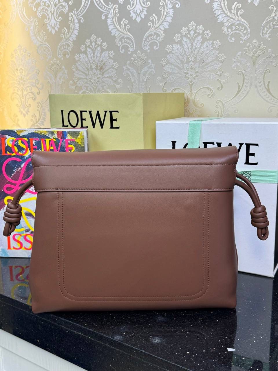 【全皮布朗尼色】 𝙇𝙤𝙚𝙬𝙚 𝙁𝙡𝙖𝙢𝙚𝙣𝙘𝙤 𝙎𝙖𝙩𝙘𝙝𝙚𝙡 福袋款邮差包 ➕刺绣🅾️字母宽肩带 编码：062404 尺寸：𝟑𝟒-𝟏𝟐-𝟐𝟒𝐜𝐦 新款以经典福袋收缩打结为元素，采用内部麂皮➕外部进口小牛皮➕刺绣字母宽肩带的精致搭配打造全新升级款邮差包🅰️，可斜挎、肩背和手提，超大容量满足日常所需🎈