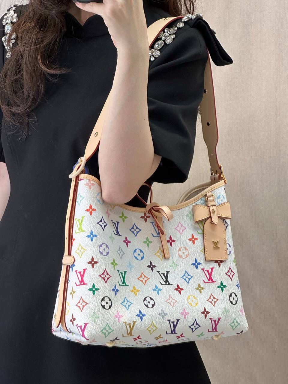 LV 白三彩 Carryall 👜✨ 这是那种—— 一背上街，别人会多看你两眼的包 🌈 白底三彩像把颜色撒进 Monogram 里， 樱花、熊猫跳出来那一刻， 整个包都在发光 ☀️ 不是甜腻，是很有态度的可爱。 Carryall BB 包型软软的、容量却很能装， 通勤不无聊，出游更加分。 蝴蝶结、链条点缀得刚刚好， 甜酷之间拿捏得很准。 如果你已经看腻普通老花， 那这只，就是春天给你的答案 🌸 📏 25 × 31 × 14 cm