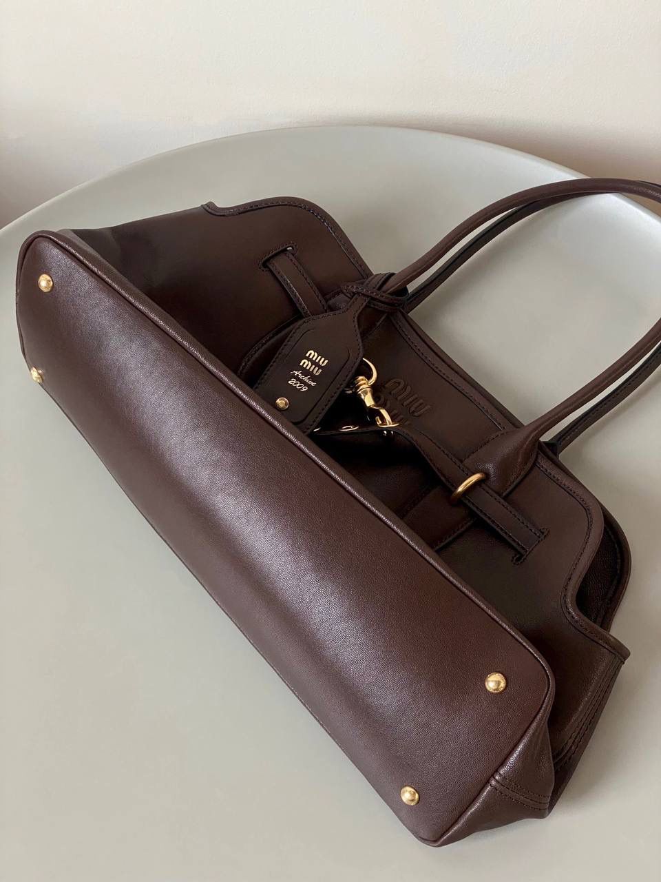 🈶石南木色 𝗠𝗶𝘂𝗠𝗶𝘂 手提包·横版 这只Aventure我要夸爆它！ 绝对是公文包中的颜值天花板 这款有多难买不用多说，绝对的断货王 酷酷的慵懒感洋气且时髦 还有一丢vintage感，超有调 上班通勤，日常出街都超出片 22.5×44×14.5cm #F0023m