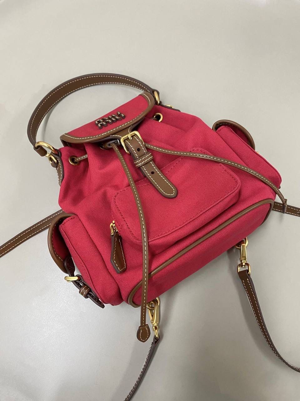 🈶帆布红，小号 𝐌𝐢𝐮𝐌𝐢𝐮 双肩包 喔噻！缪缪终于出双肩包了！ 超级经典的款，配色也是无敌了 多个口袋设计非常复古学院风，青春洋溢！ 五金质感超绝，带有微微做旧的复古磨砂感 这种材质耐用度极高 帆布版俩个颜色都好看！正红色，越看越爱是最最最推荐的 ！ 总的来说夏天就是要拿个亮色的出游 轻便实用 小号：18×22×11.5cm #F0060m 大号：25x29x12.5cm